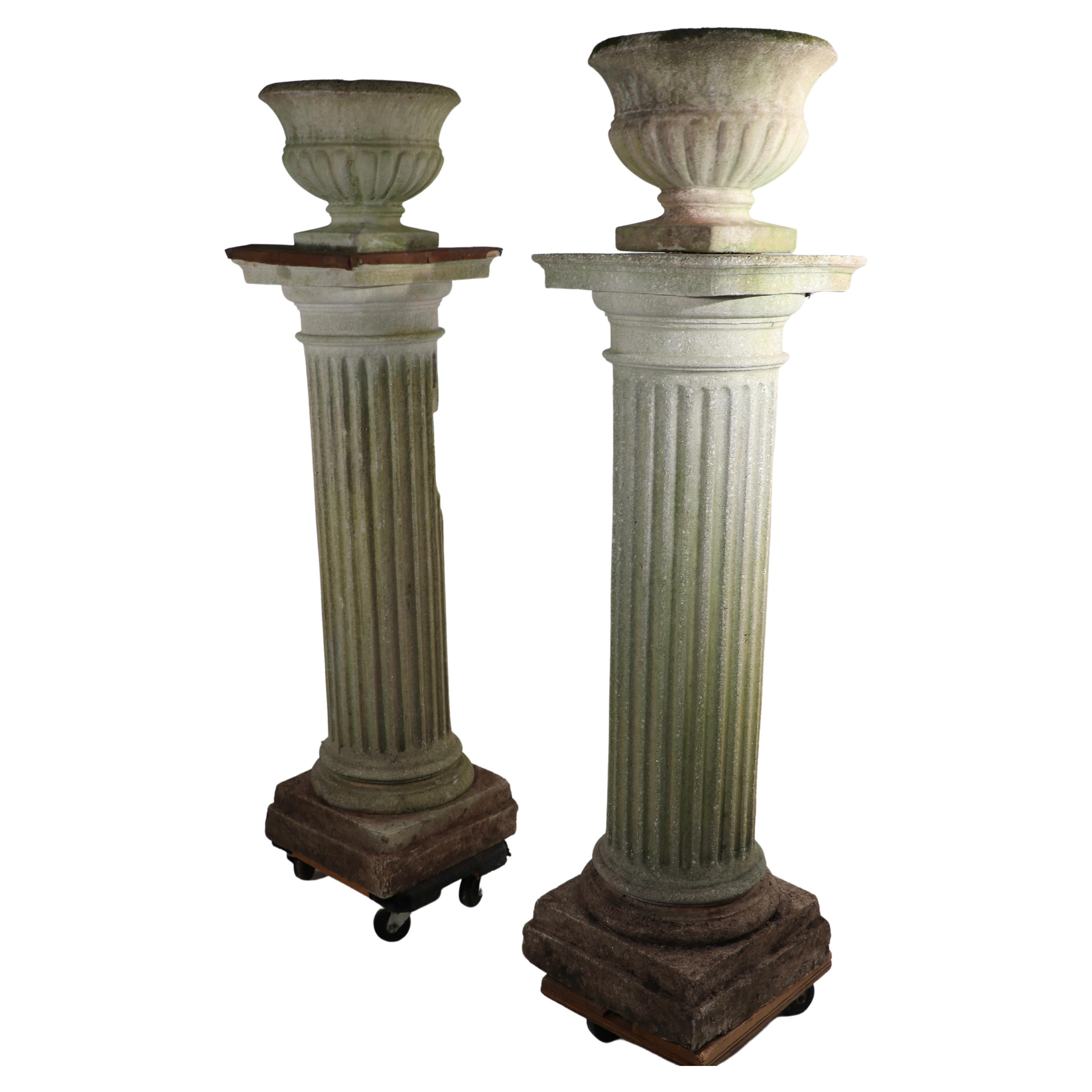 Impressive pair of cast stone Roman Doric style columns each having a cast stone Campania from jardiniere, planter mount. The planters are removable if you have other design schemes calling only for columns. Oddly, one top has a vertical post, which