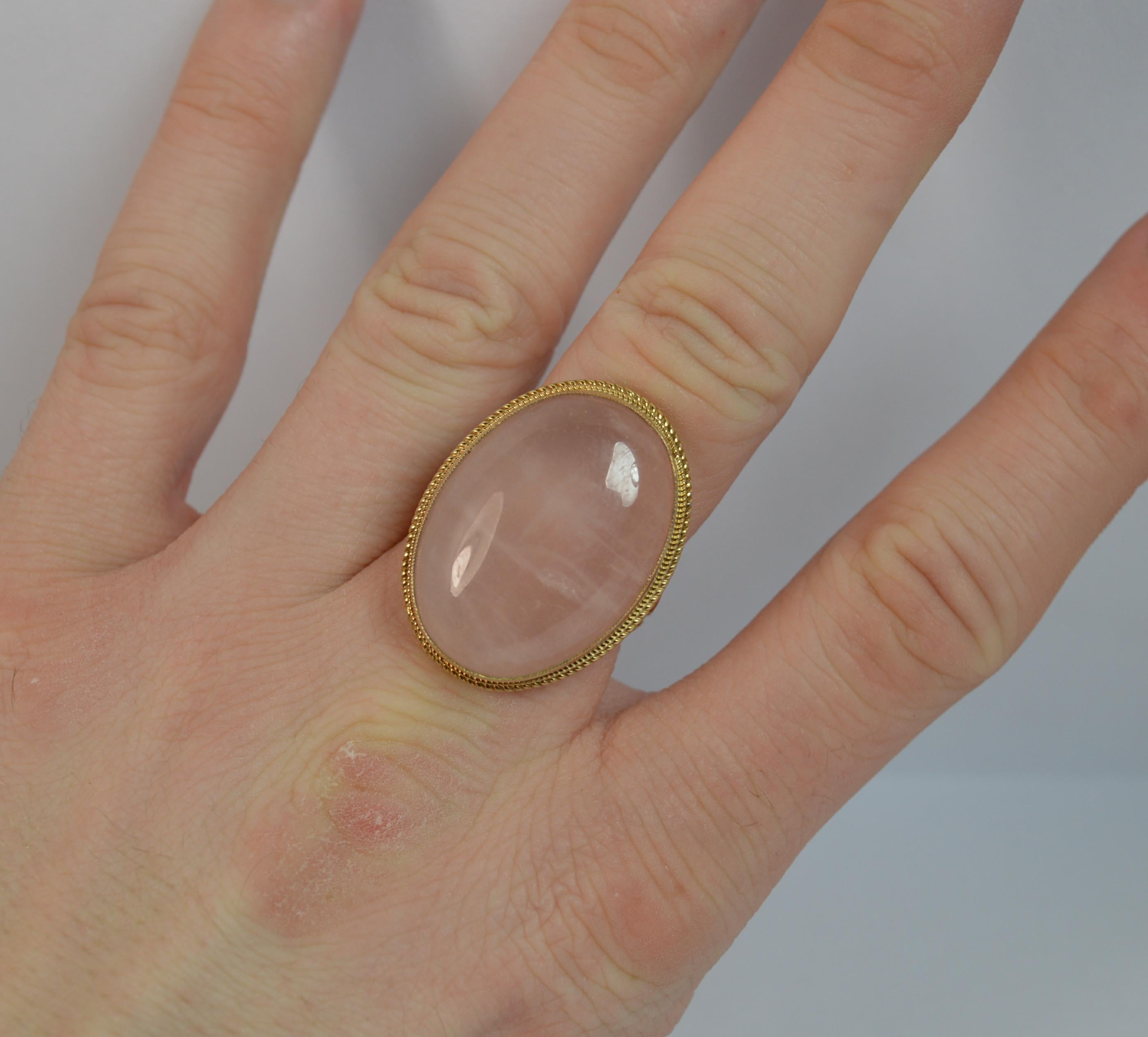A beautiful ladies 9 carat gold and rose quartz ring.
Size ; P 1/2 UK, 8 US
18mm x 25mm rose quartz with gold twist surround. 9mm off the finger.

Large statement example.

Condition ; Excellent. Well set stones. Clean, strong, round band. Issue