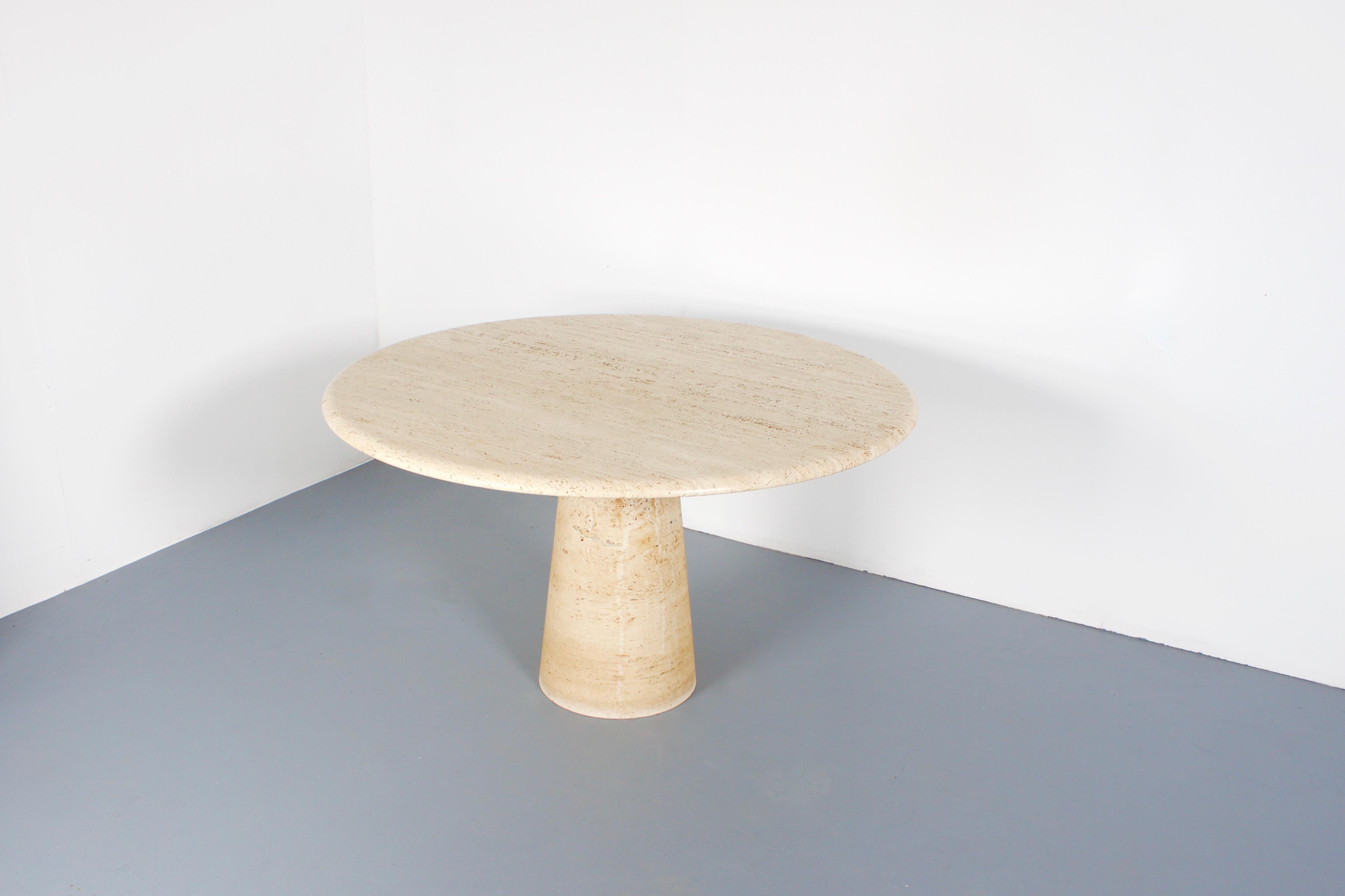 Very heavy high quality Italian travertine marble dinner table, 1970s.

Thick travertine top in variegated tones of beige and brown.

The top rests on a unique cone-shaped pedestal base also in travertine. 
It balances perfectly and securely by it's