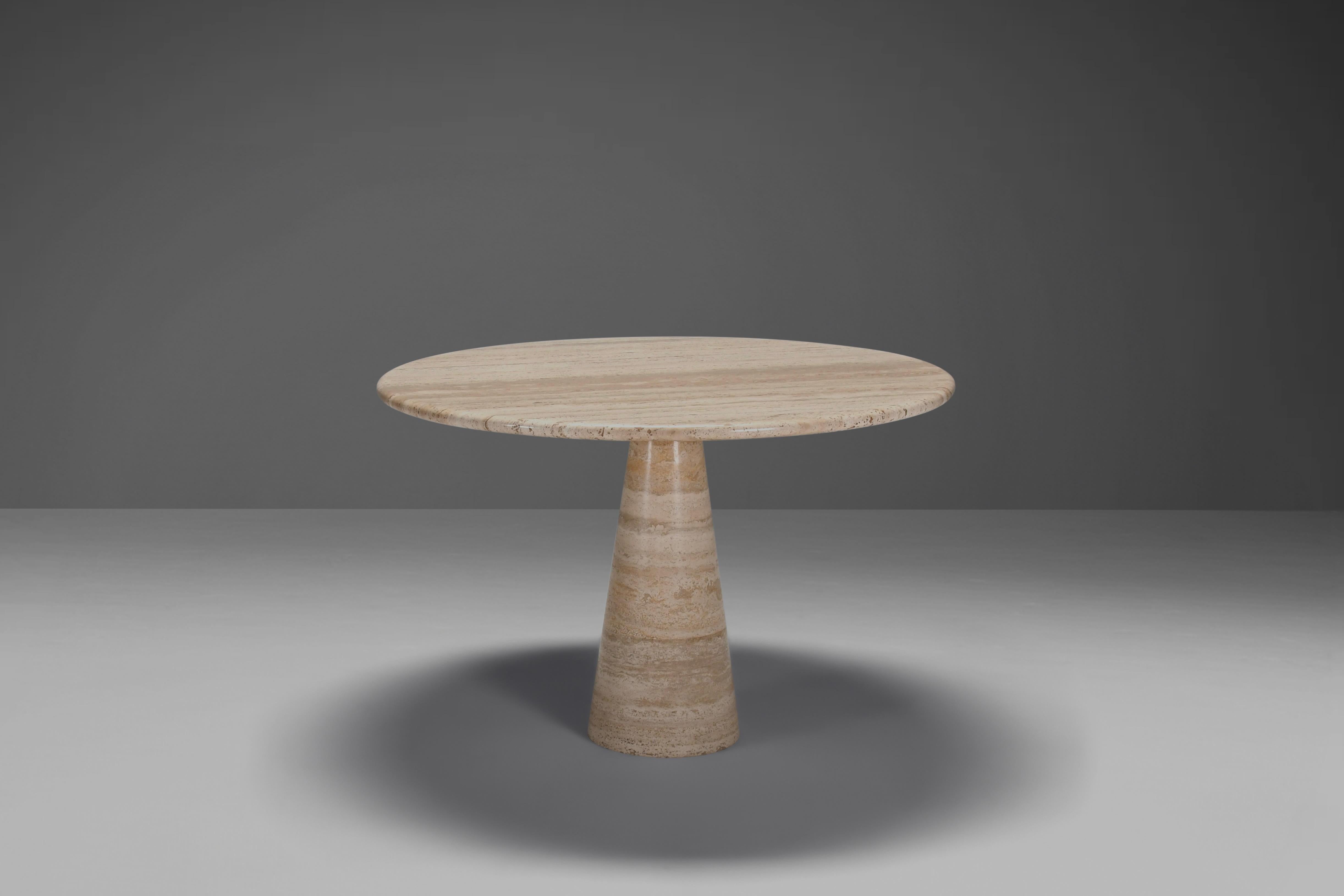 Table de salle à manger en marbre naturel italien travertin en très bon état.

Plateau en travertin épais dans des tons variés de beige et de brun. 

Le plateau repose sur un socle rond de forme conique, également en travertin. 

Le sommet et la