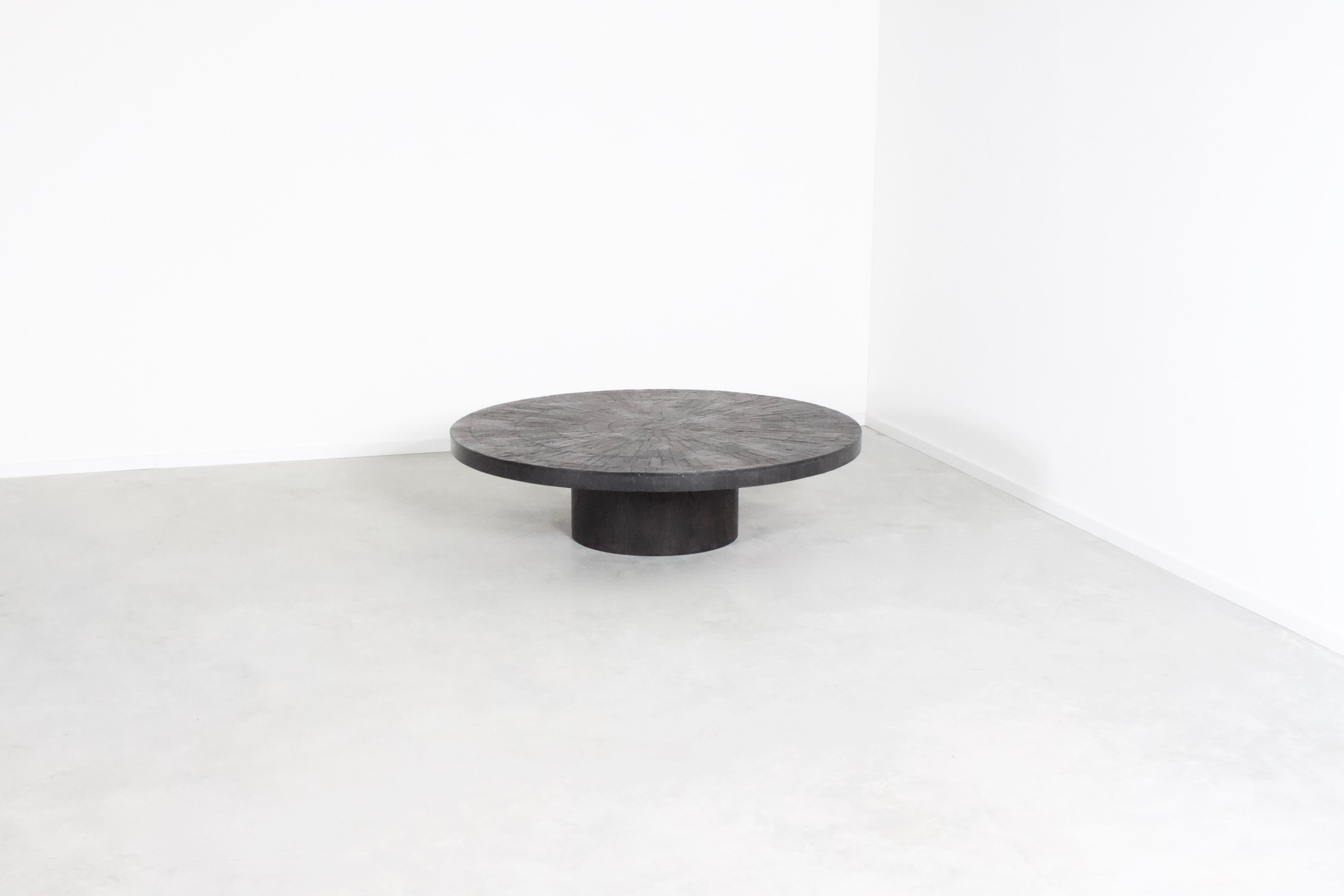 Beautiful 1970s mosaic coffee table in very good condition.

Designed by Heinz Lilienthal

The round top of this table is made in a beautiful black slate mosaic.

The rims of the top are also made of slate.

The centered round base is made of