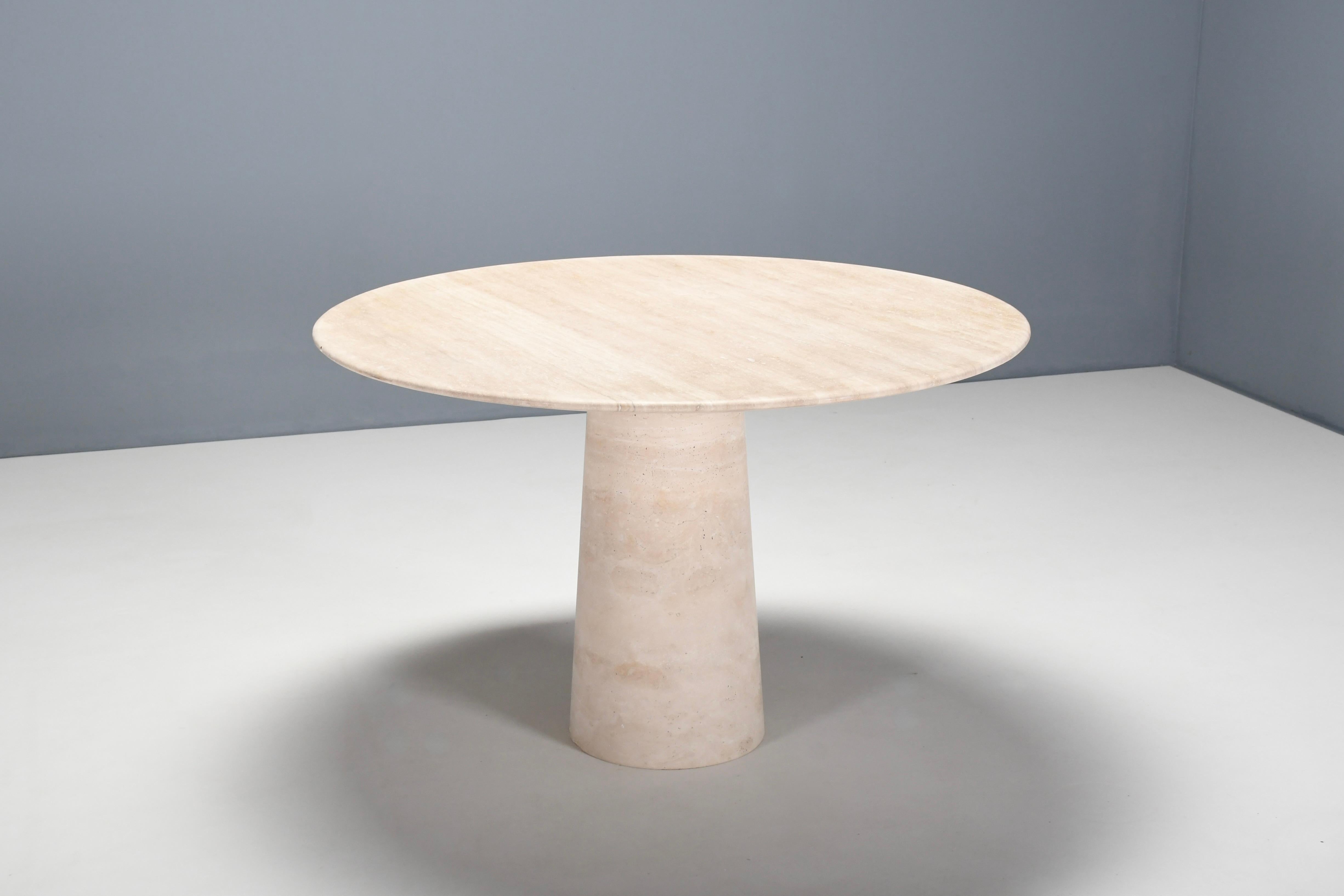 Natural Italian travertine marble dining table in very good condition.

Thick travertine top in variegated tones of beige and brown. 

The top rests on a round, conical shaped pedestal base also made of travertine. 

The top is securely connected to