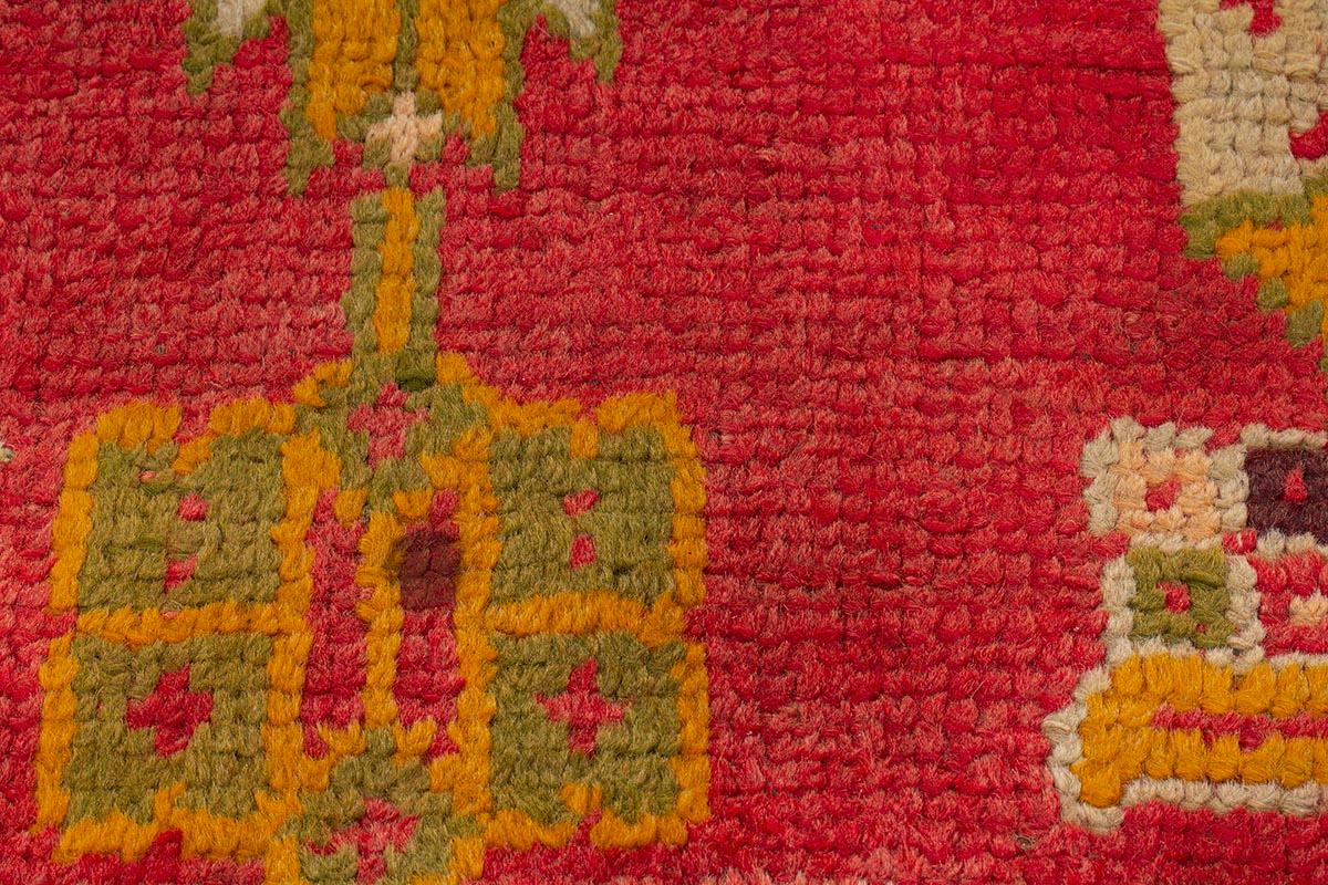 Con un'estensione di 642 cm, questo tappeto Oushak della fine del XIX secolo e dell'inizio del XX incorpora un motivo regolare di medaglioni, teste di fiori stilizzate e dettagli fogliacei su un ricco fondo cremisi, con gialli e verdi mela che si