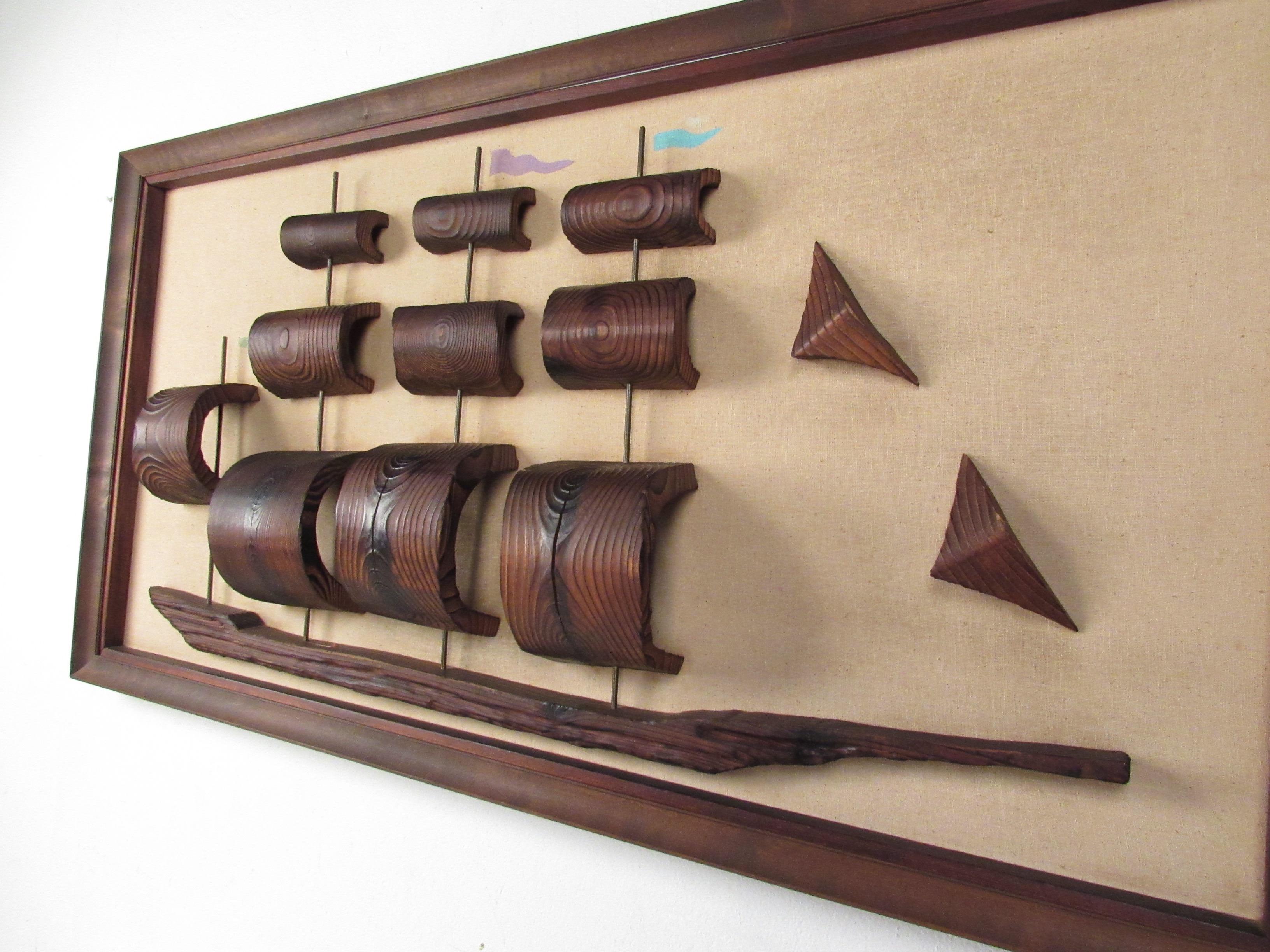 Cet impressionnant tableau mural du milieu du siècle présente un bateau clipper en bois sculpté avec des détails uniques et un attrait moderne sculptural. Le cadre en bois assorti ajoute à l'attrait vintage saisissant de cette pièce nautique, qui