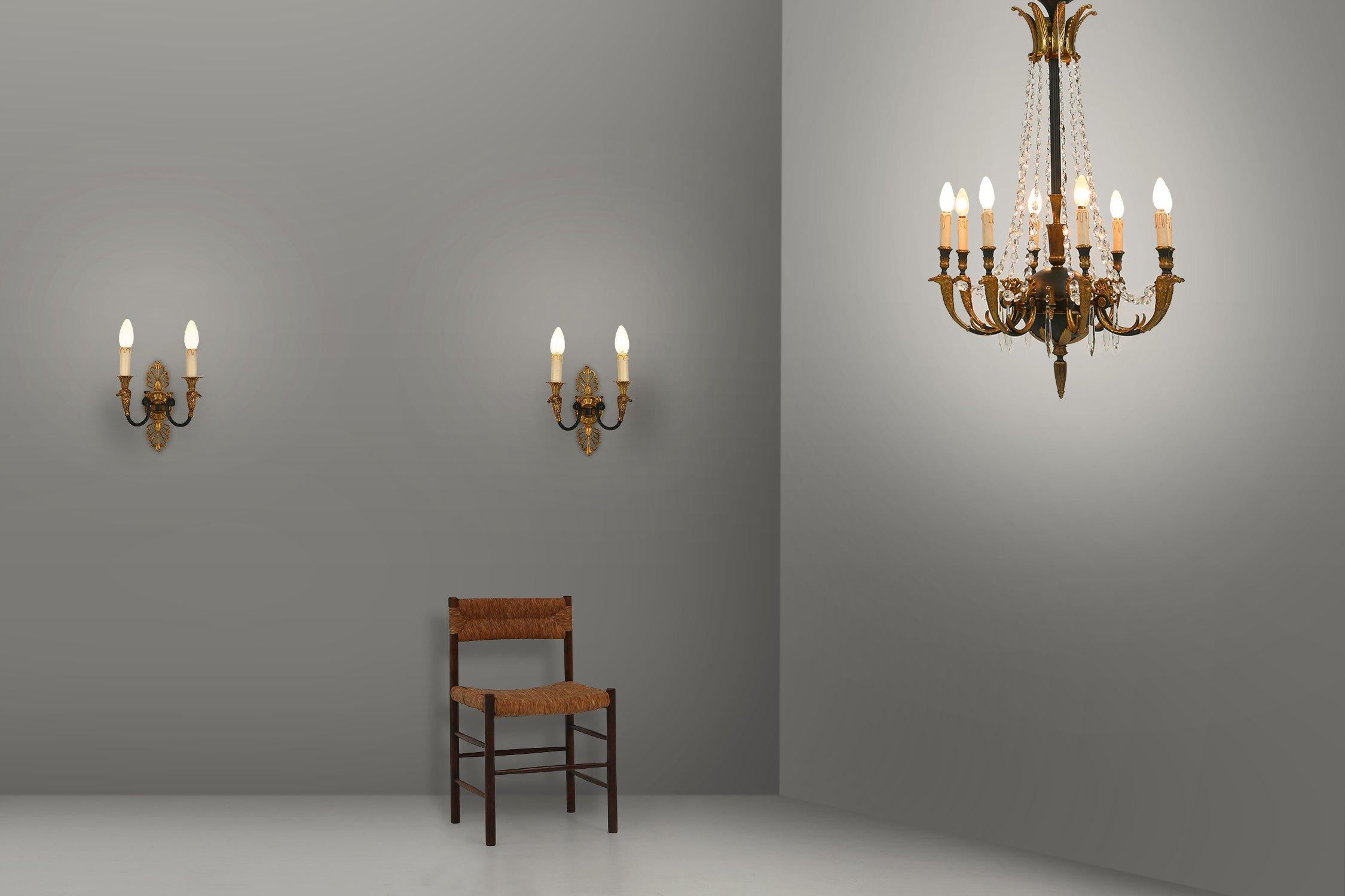 Belgium / 1950 / chandelier or pendant lamp with 2 wall lamps / bronze and glass / empire

A beautiful set containing a large Chandelier with 8 light arms and 2 wall lights with each 2 arms. Made in bronze in Belgium in the 1950s in Empire style.