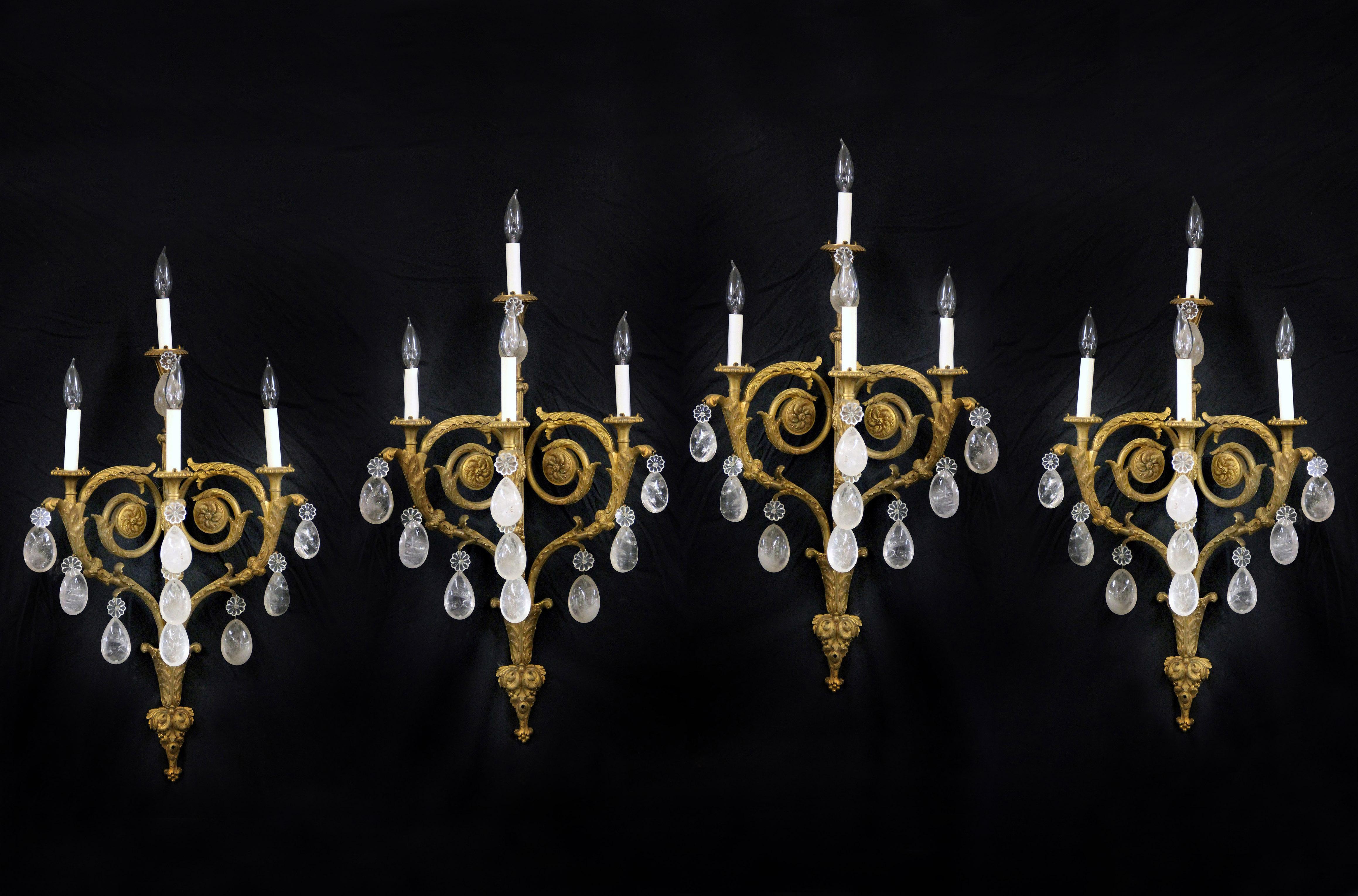 An impressive set of four late 19th century gilt bronze and rock crystal four light sconces

Tear drop shaped crystal, foliate-scrolled arms and backplate, centered by a spiral arm with four tiered lights.