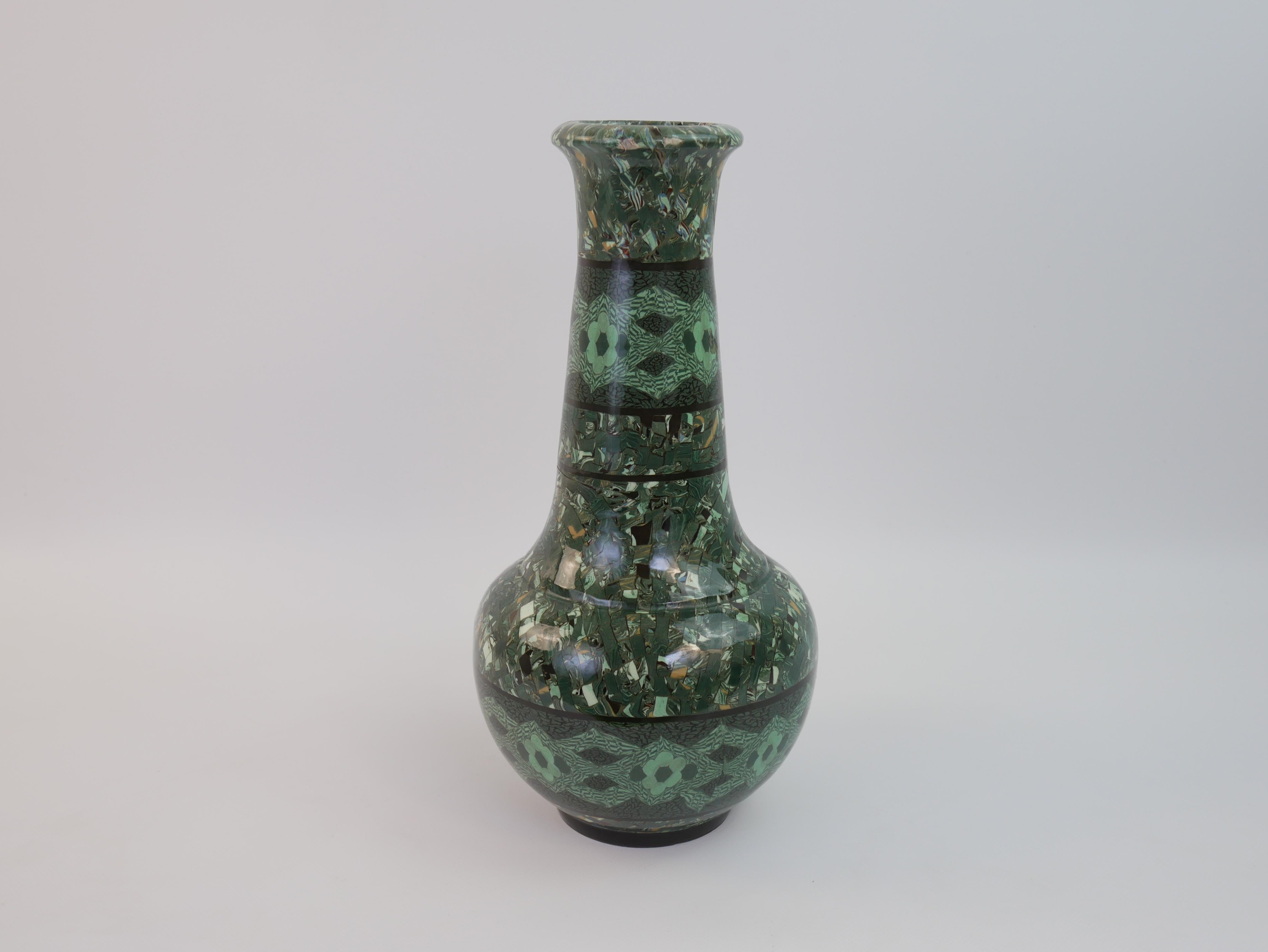 Impressionante vaso alto in ceramica verde. Questo vaso, realizzato da Jean Gerbino a Vallauris negli anni '50, è un esempio della sua innovativa tecnica terre-mêlée. I suoi intricati disegni, formati miscelando argille di diverse tonalità di verde,