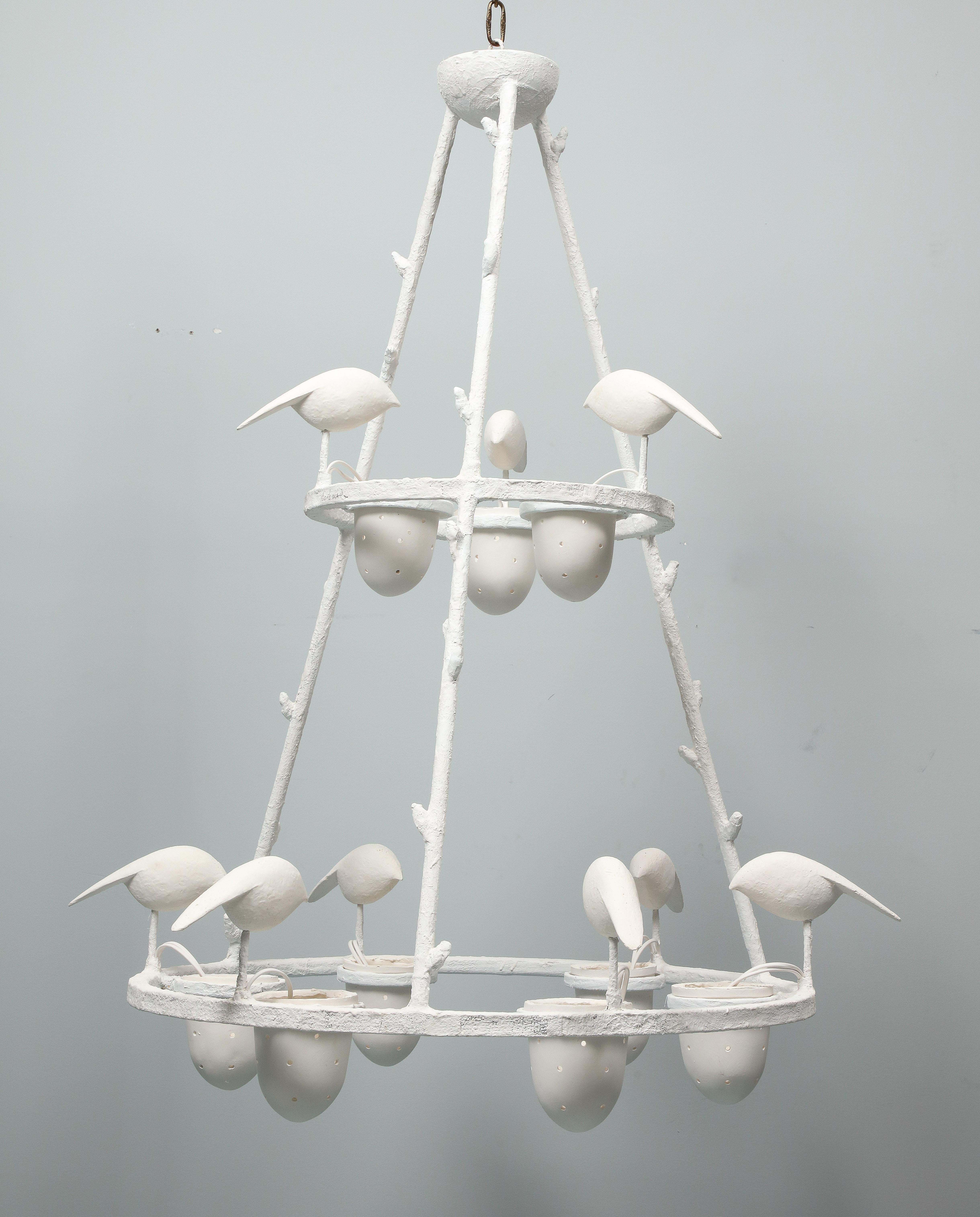 This chandelier is impressive by its scale. It has been created and made by Jacques Darbaud. The structure which is in metal, is covered by white plaster. It has 9 lights, American wired. The design shows birds perching on the frame and pecking in