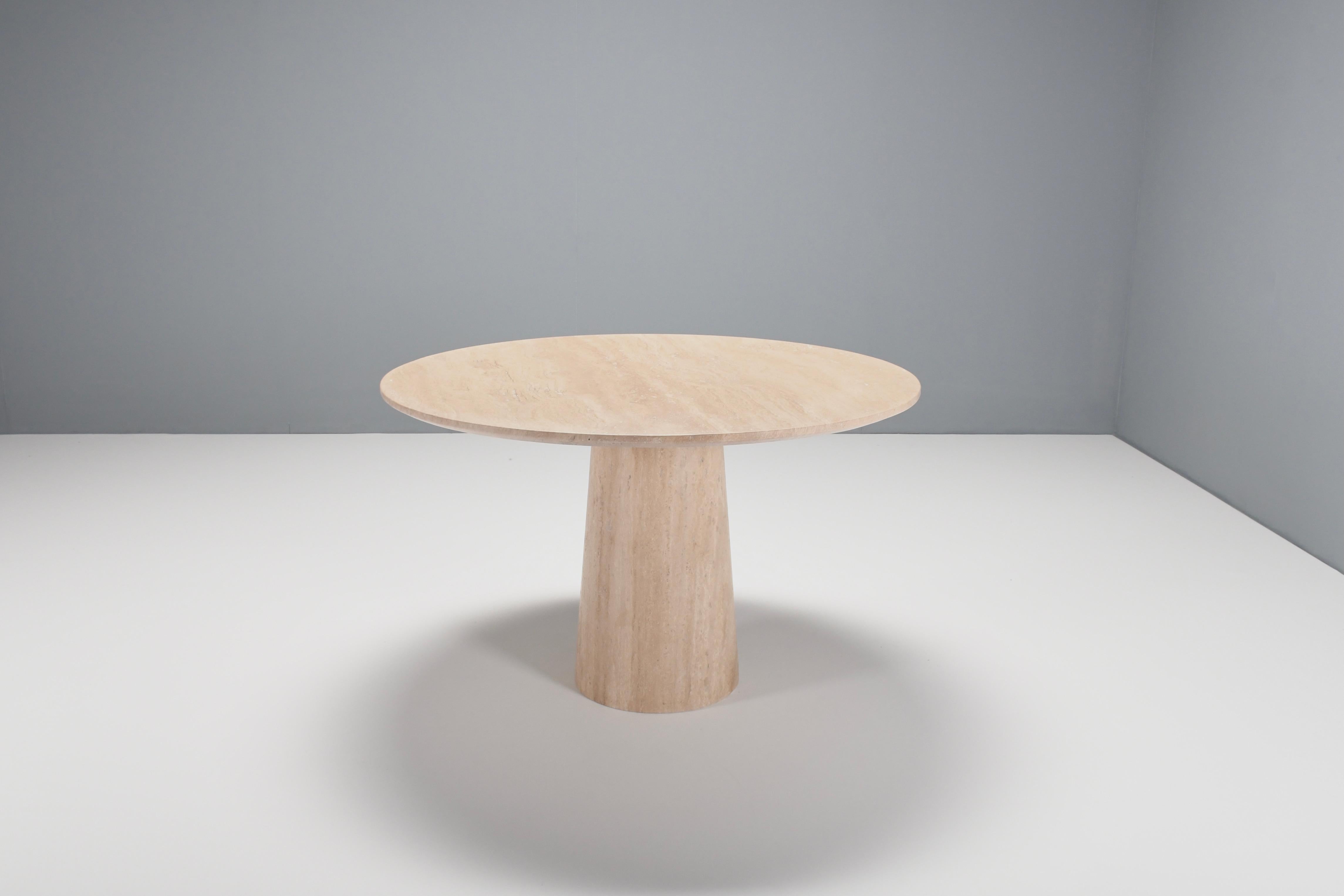 Natural Italian travertine marble dining table in very good condition.

Thick travertine top in variegated tones of beige and brown. 

The top rests on a round, conical shaped pedestal base also made of travertine. 

The top is securely