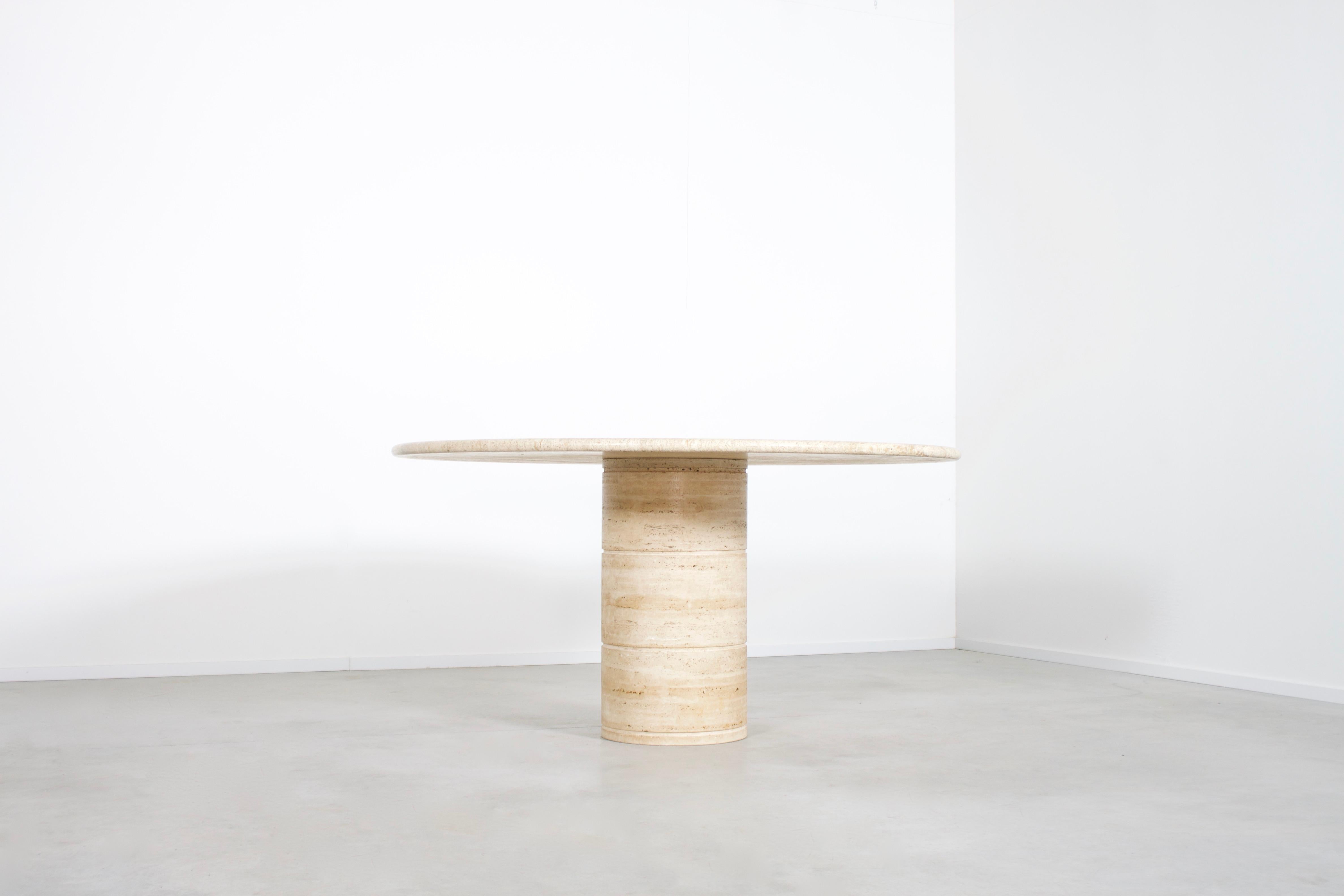 High quality Italian travertine marble table in very good condition.

Issued by Up & Up Italy in the 1970s

Thick travertine top in variegated tones of beige and brown. 

The top rests on a round pedestal base also made of travertine. 

The top