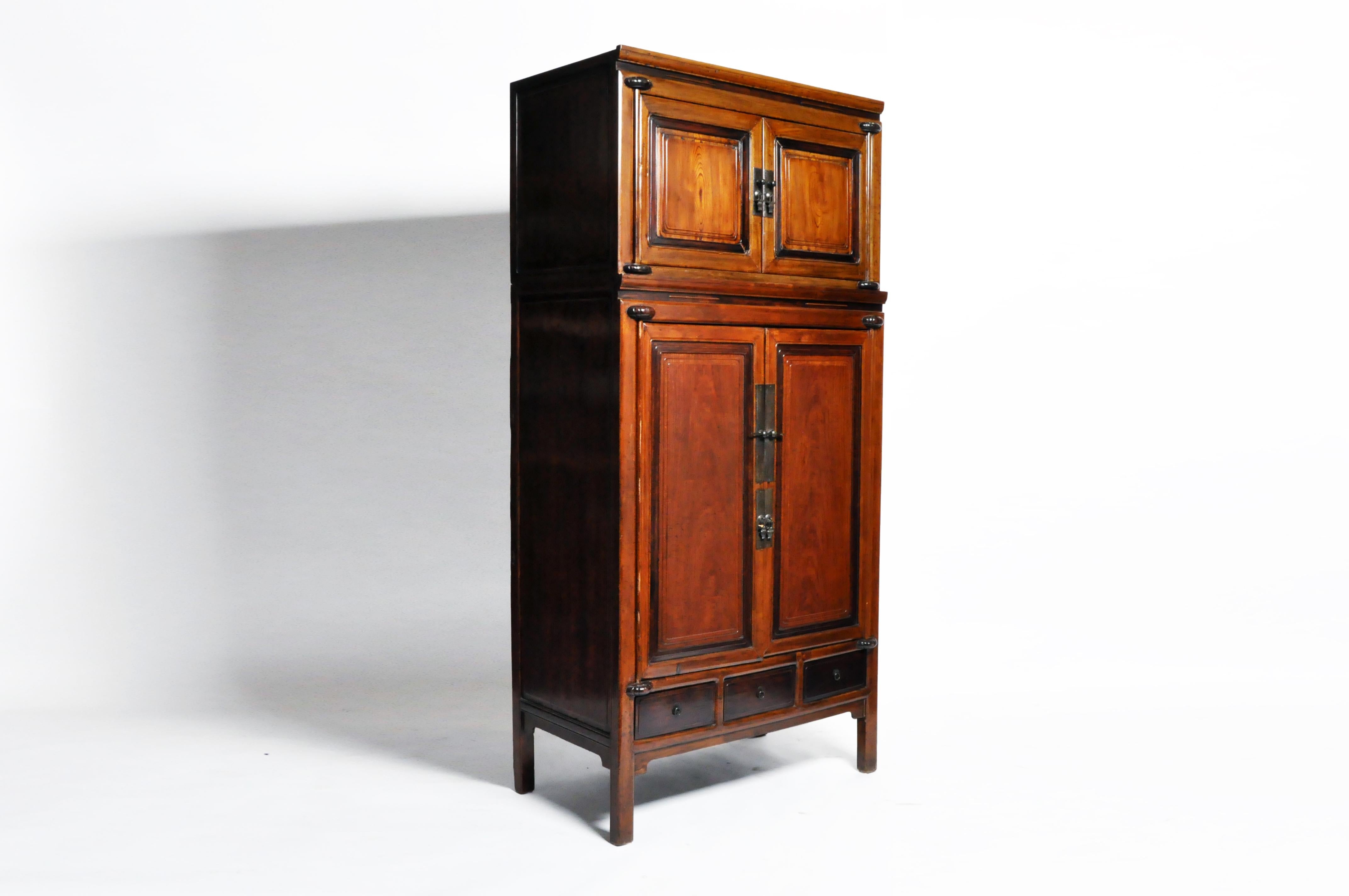 This handsome cabinet is from Ningbo, China and was made from cypress and hauli, circa 1810. The cabinet comes in two sections and features a pair of doors, 5 drawers, and shelves for ample storage. The piece has been restored and has a beautiful