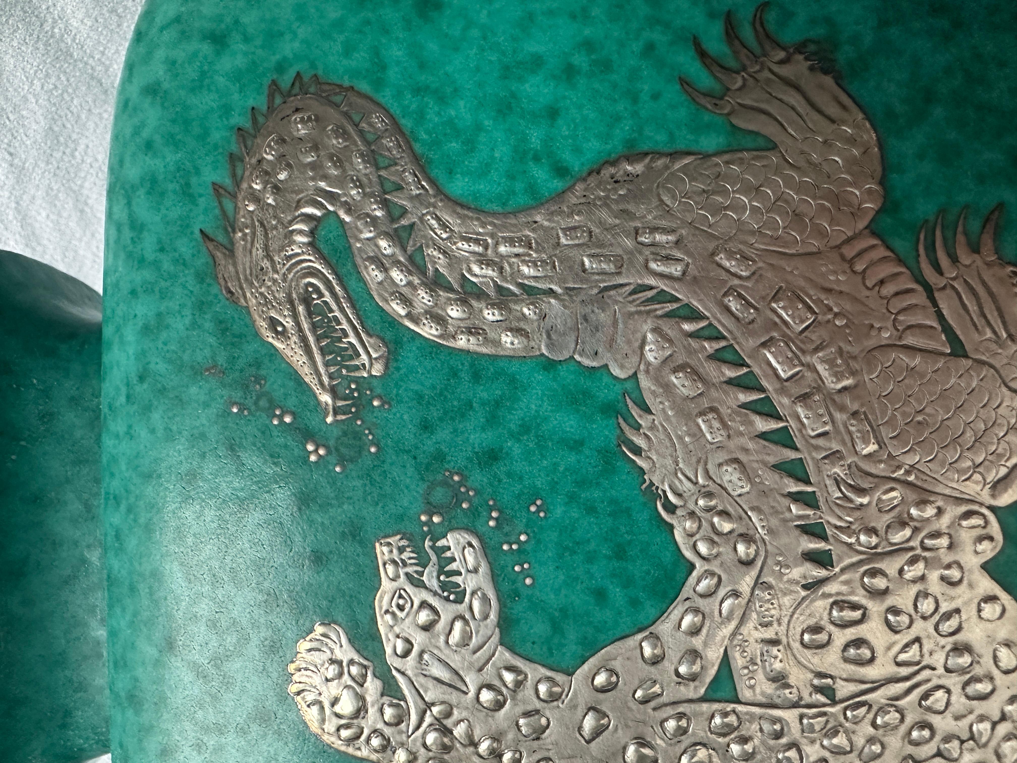 Very rare large urn, figuring silver inlay with a dragon and a panther one one side and stylised flowers on the other side. Signed GUSTAVSBERG ARGENTA with anchor 1207.

Wilhelm Kåge (1889-1960) is one of the most well-known representatives of the
