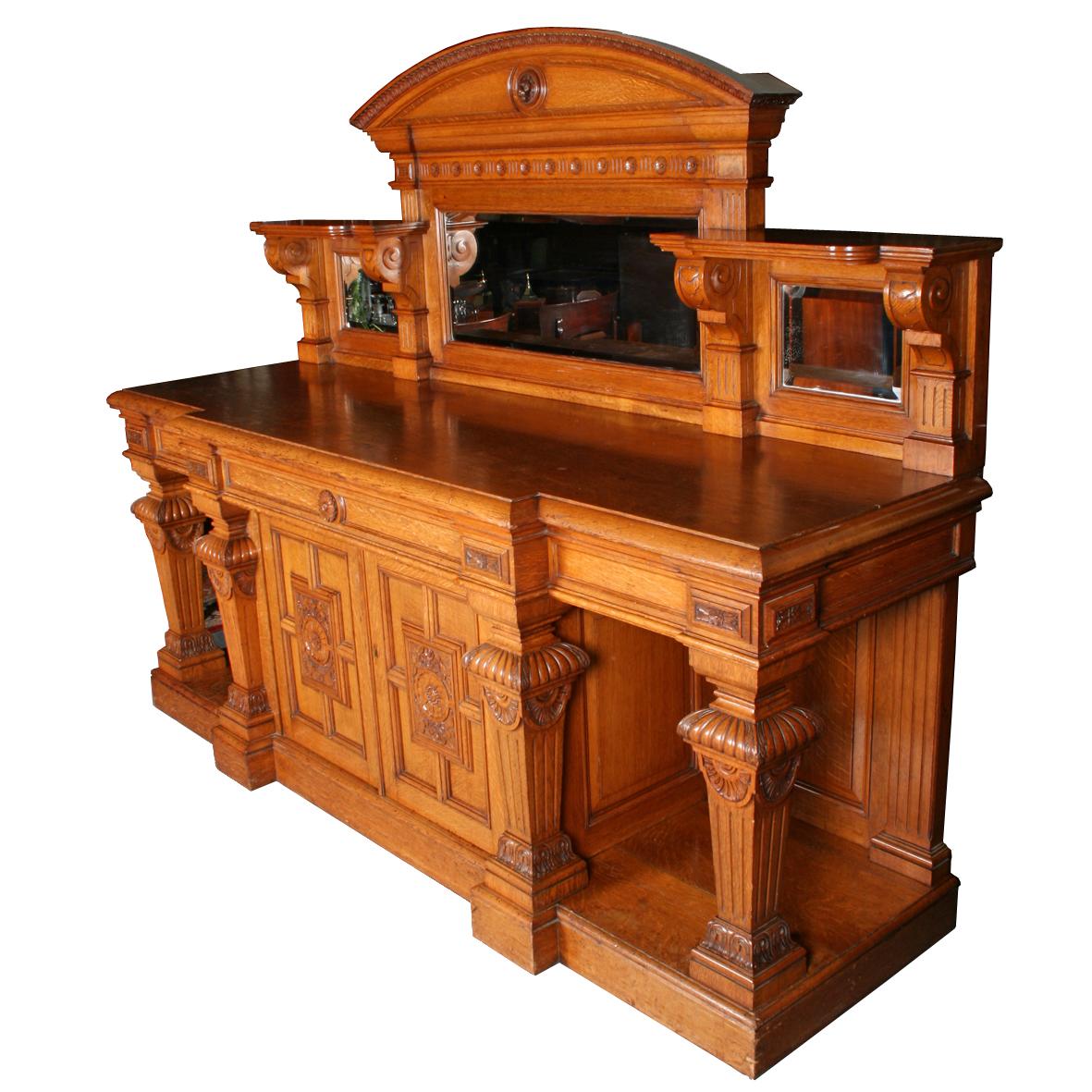 A large 19th century Victorian oak sideboard with a triple mirror back.

The base is breakfront in shape, has three concealed drawers in the front frieze, and four large square tapering and carved ballusters supporting the top.

One of the
