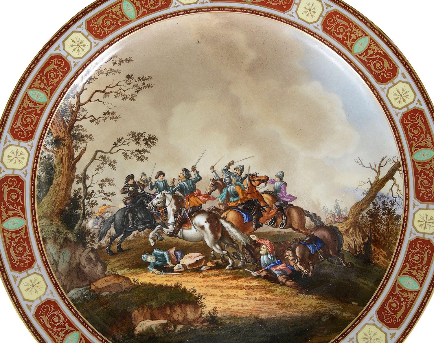 This late 19th century Vienna porcelain charger features a vibrant and dynamic scene of a cavalry battle. The central artwork depicts soldiers engaged in combat, mounted on richly adorned horses, highlighting the ferocity of the conflict. The