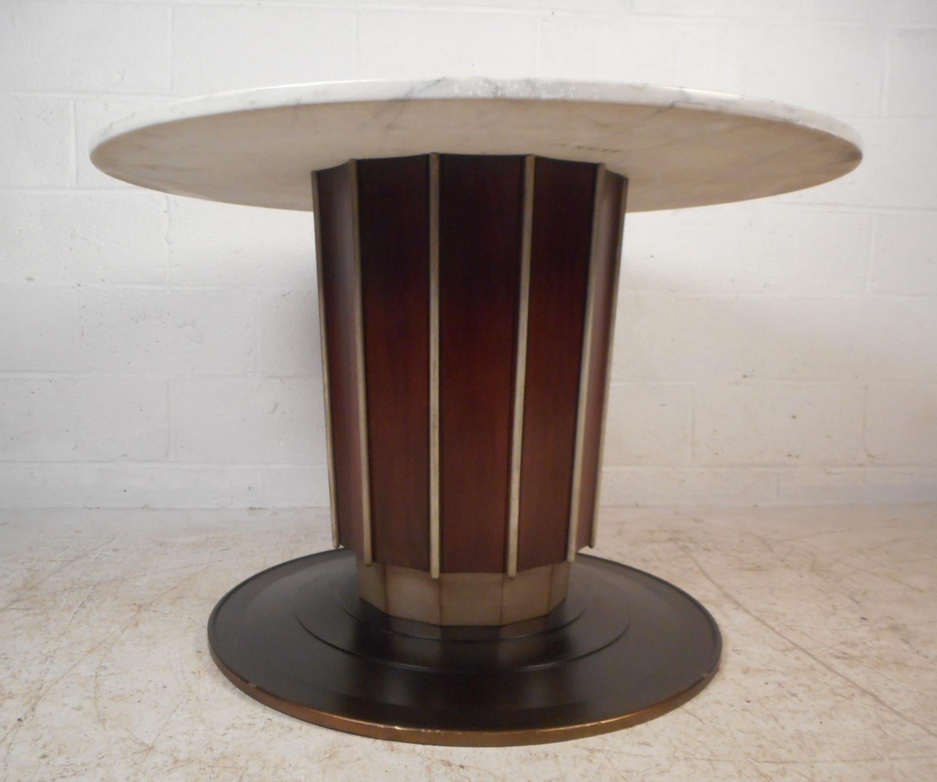 This stunning Mid-Century Modern kitchen table features a round white marble top on a pedestal base. The stylish pedestal base boasts walnut veneer with vertical accents. An elegant design that makes the perfect showpiece in any setting. Please