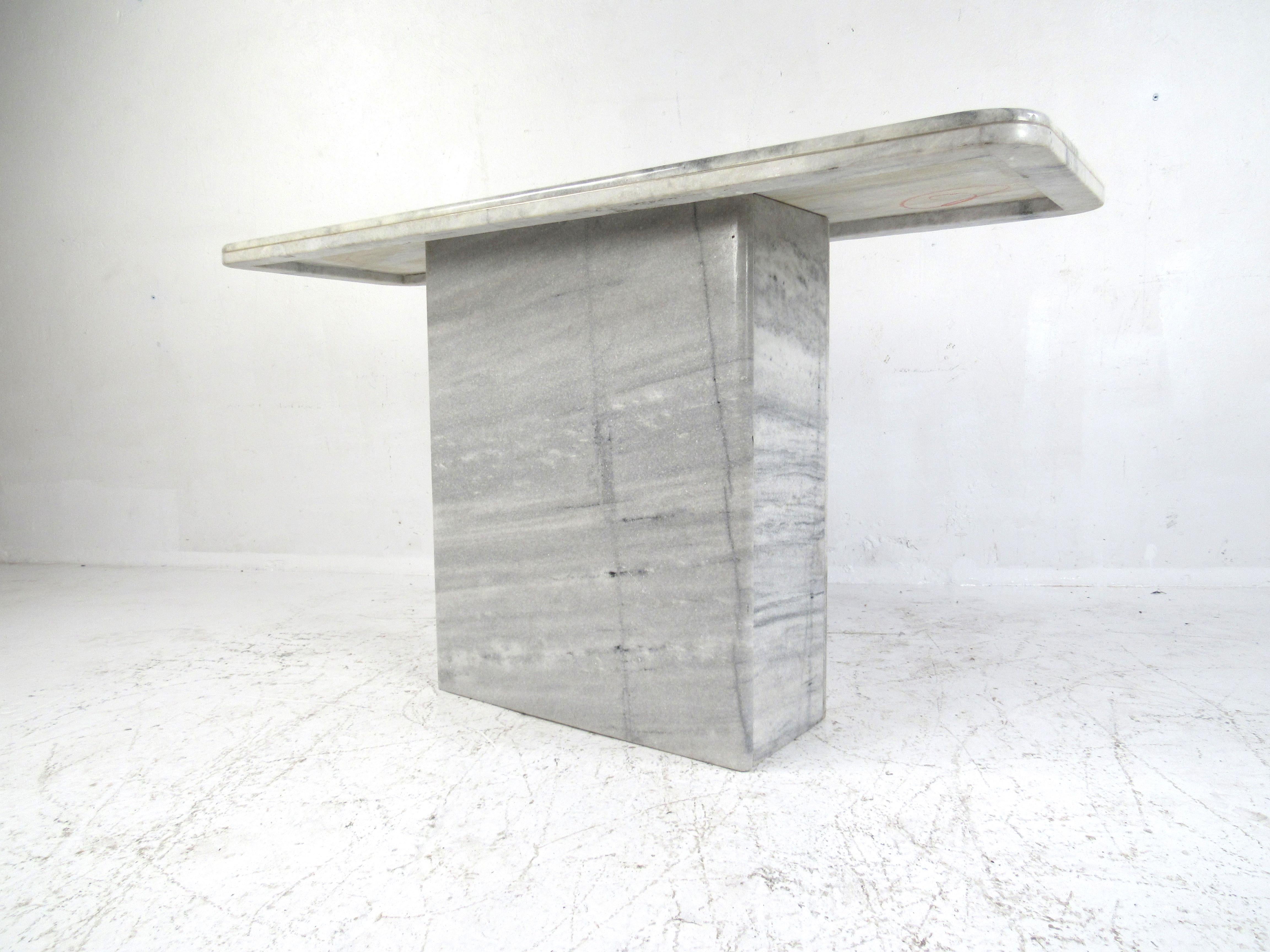 A beautiful Mid-Century Modern console table with a pedestal base and a rectangular top. This lovely marble hall table has a tone of grey and white, allowing it to fit the scheme in any setting. This table looks great in any home, business, or