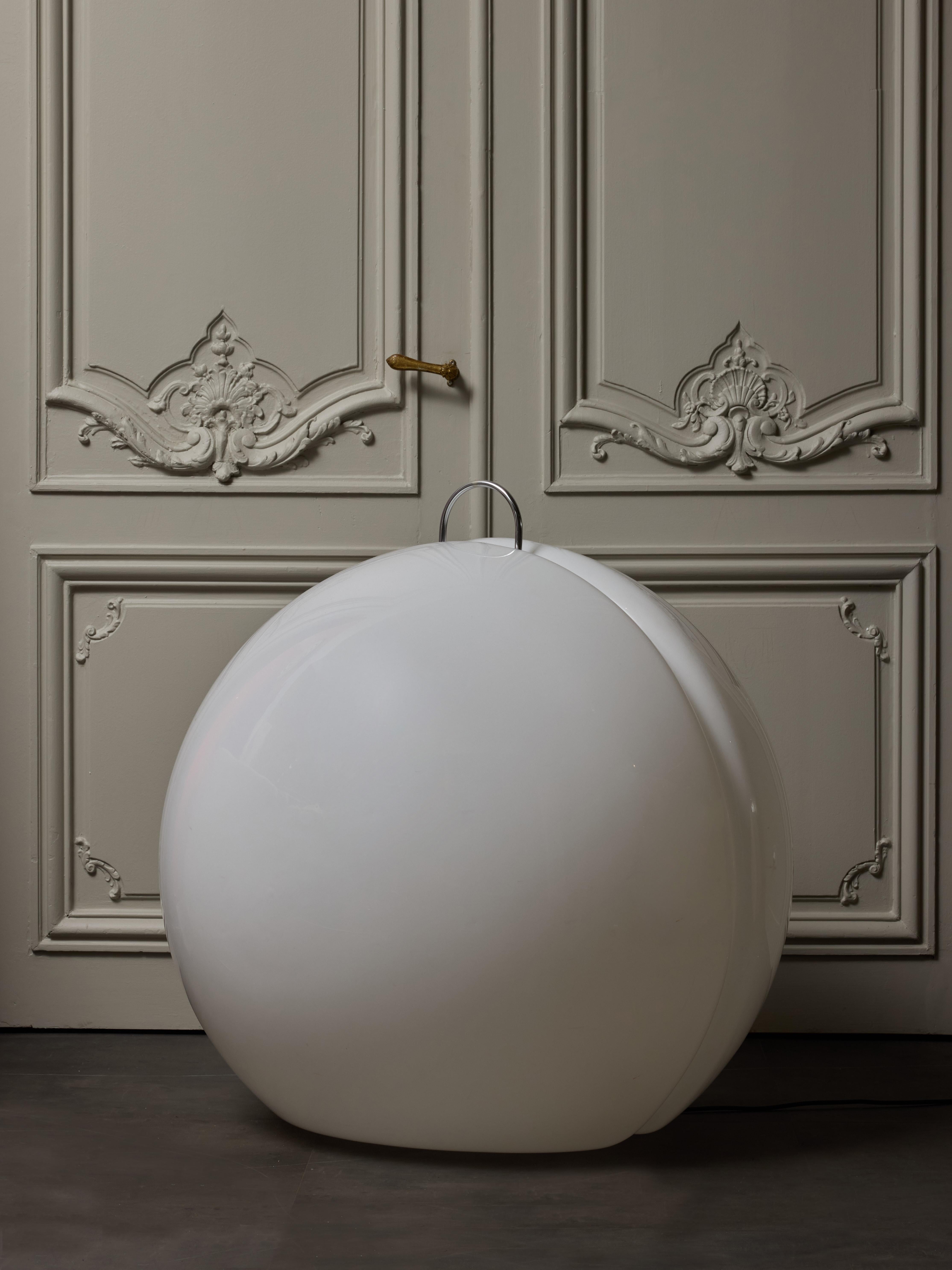 Impressive large floor lamp made of two half spheres in white plexi attached together and held in place thanks to a stainless steel handle on top.

