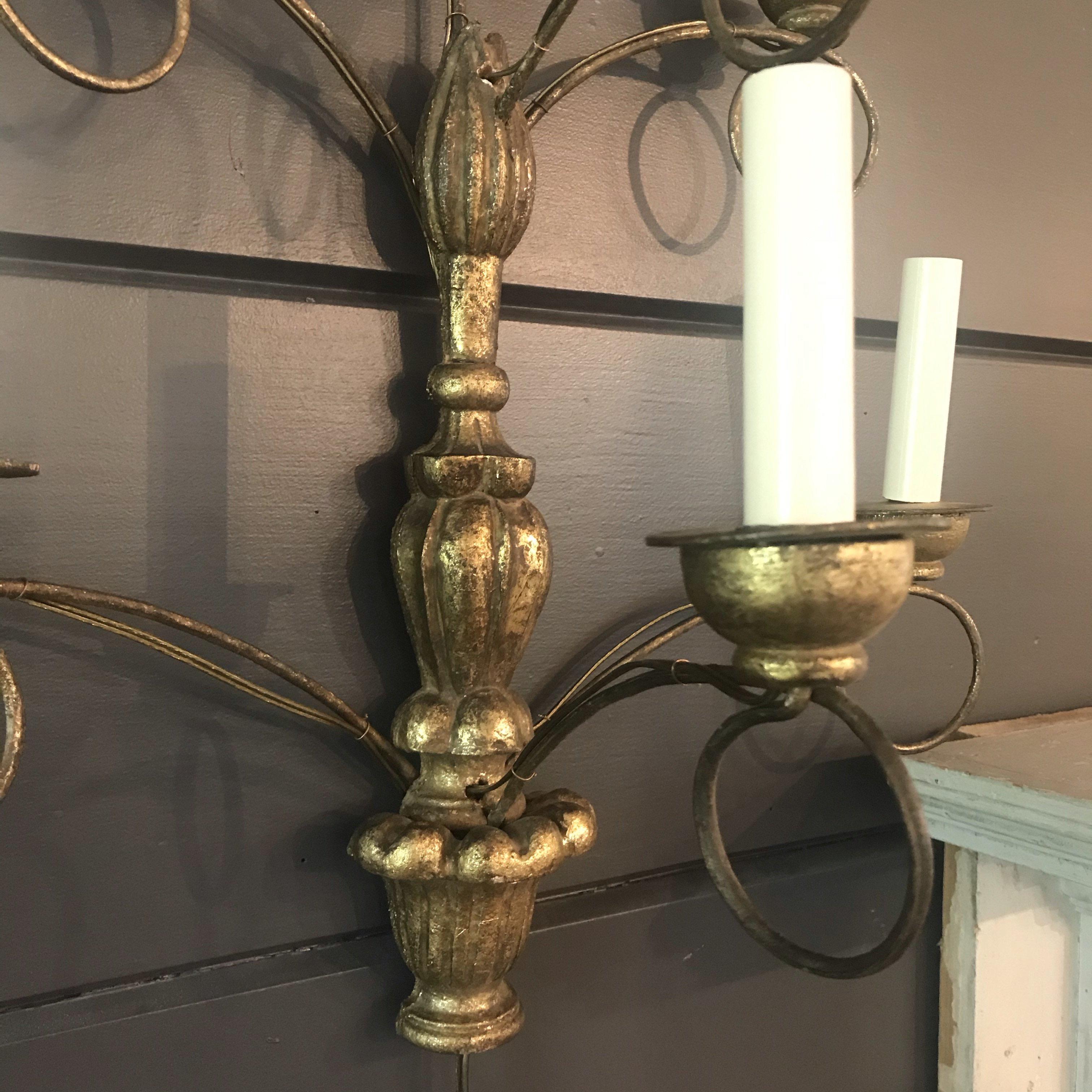 A large elegant pair of French water gilt gold carved sconces with beautiful graduated urn design, with metal scrolled arms holding seven candle lights. Bought in France and rewired to US standards.
 
Measures: H 29” x W 18” x D 9.5”
#5067.
  