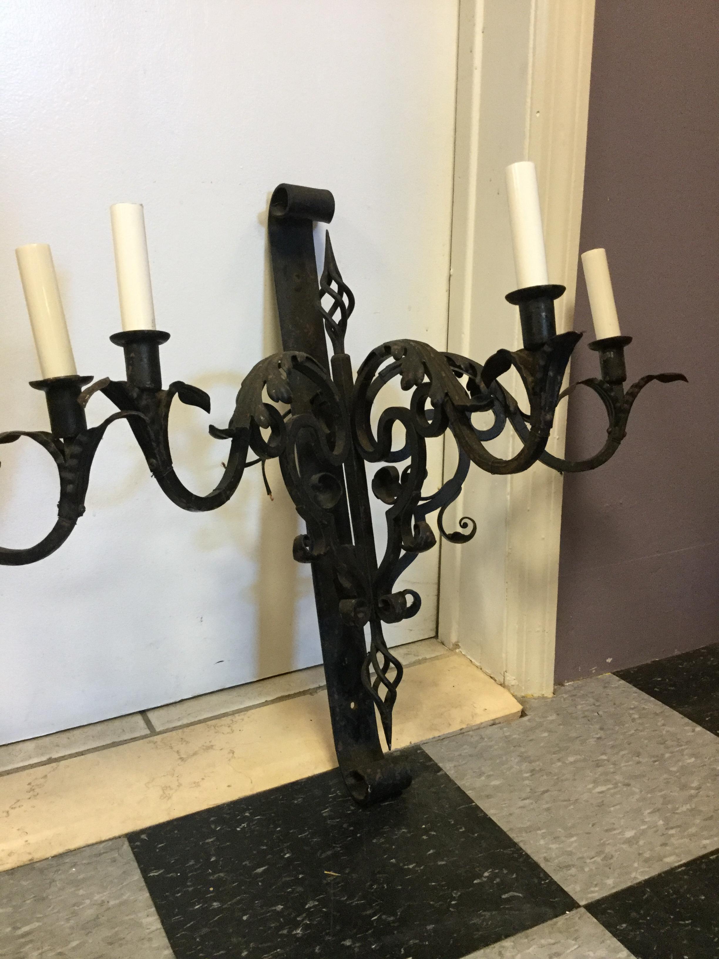 Pair of 1930s French wrought iron wall sconces. Large and imposing, these
sconces feature 3 candelabra arms each with leaf and scroll ornamentation.
Newly re-wired, each socket will accommodate a 40 watt bulb.

  