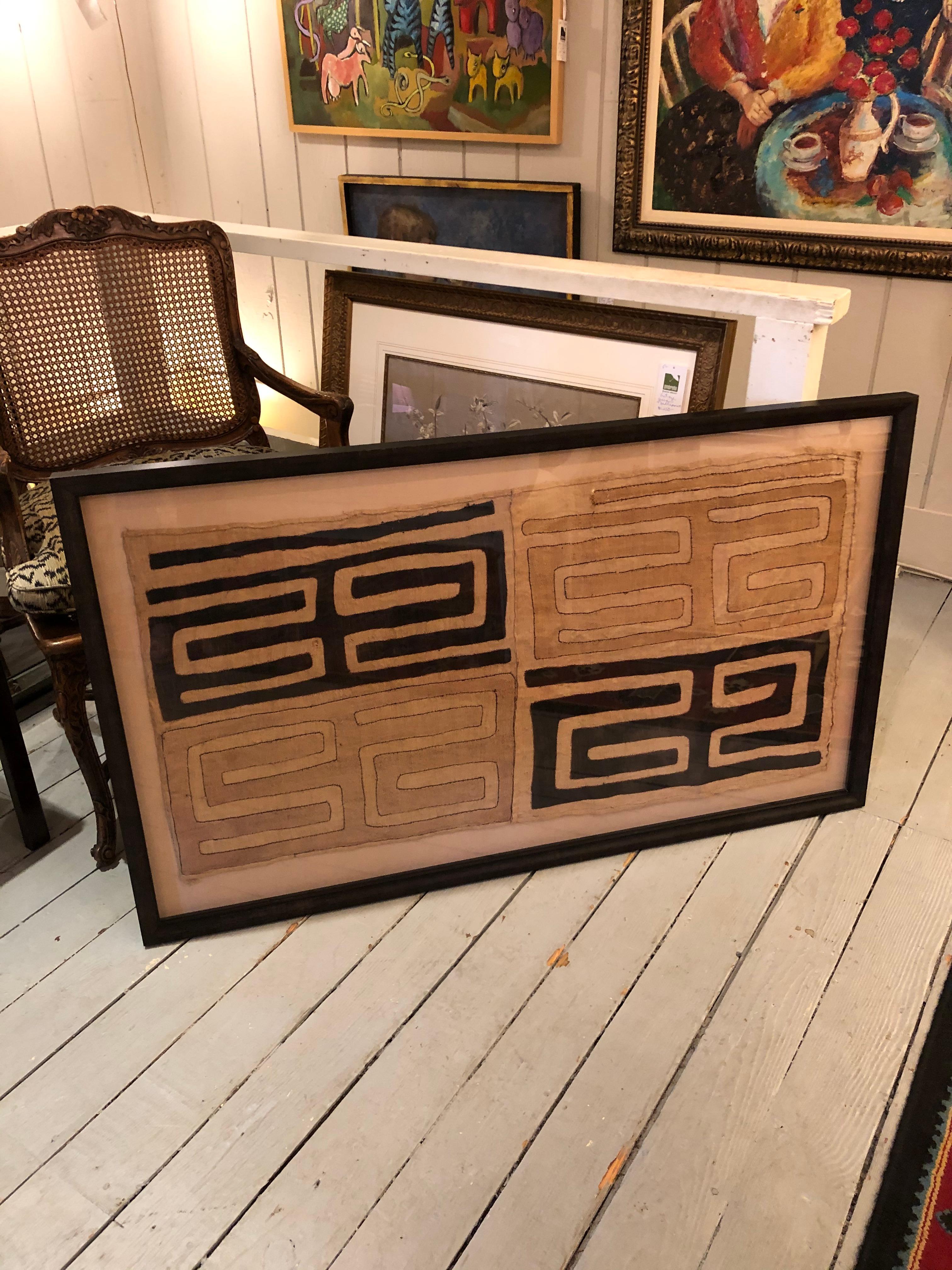 Large impressive graphic geometric African Kuba cloth in handsome custom frame having neutral color palette of beige and brown.