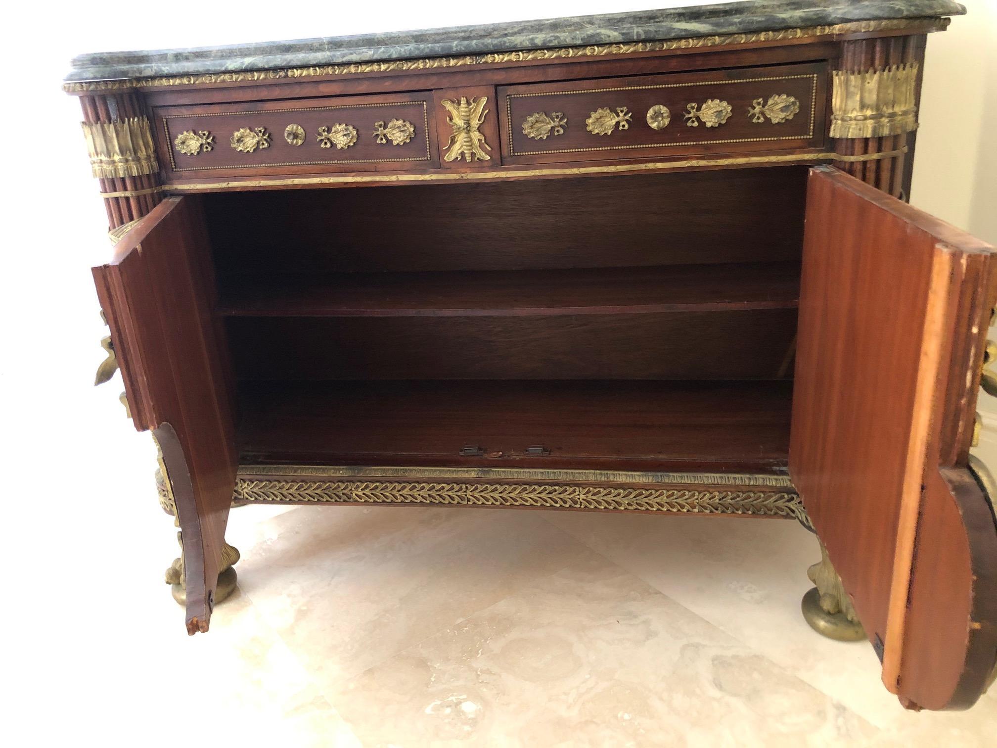 French Revolution Louis XVI style sideboard, commode or buffet having gorgeous ornate bronze decoration over inlaid marquetry body and elegant marble top. The ball and claw feet are super impressive. There are two drawers and large interior cabinet