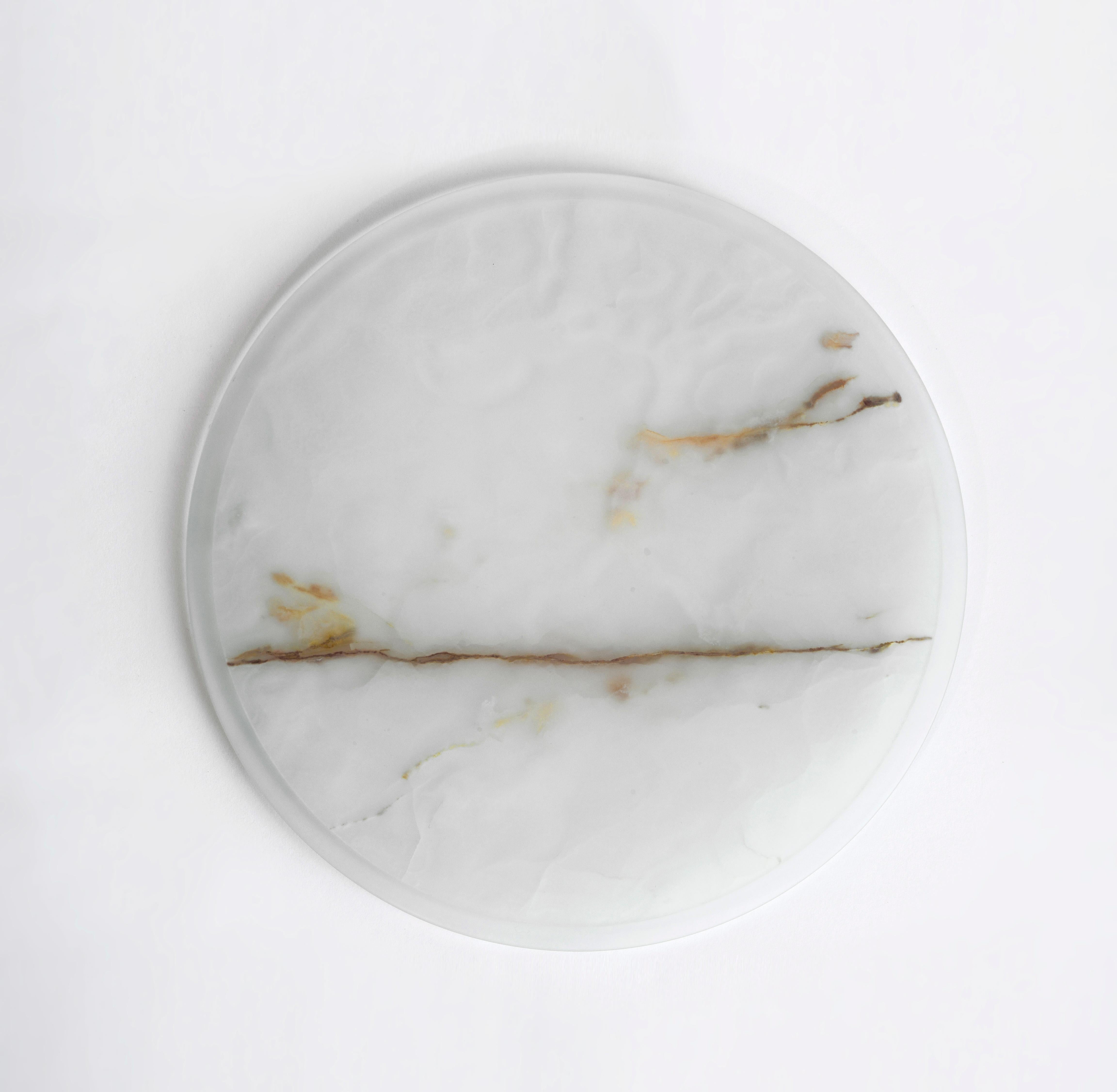 Centerpieces and serving plates in marble and glass, a slow manual processing define new forms where lightness, transparency and thickness to the structural limit become The Protagonists; vitrified signs left by time. Transparency of matter and