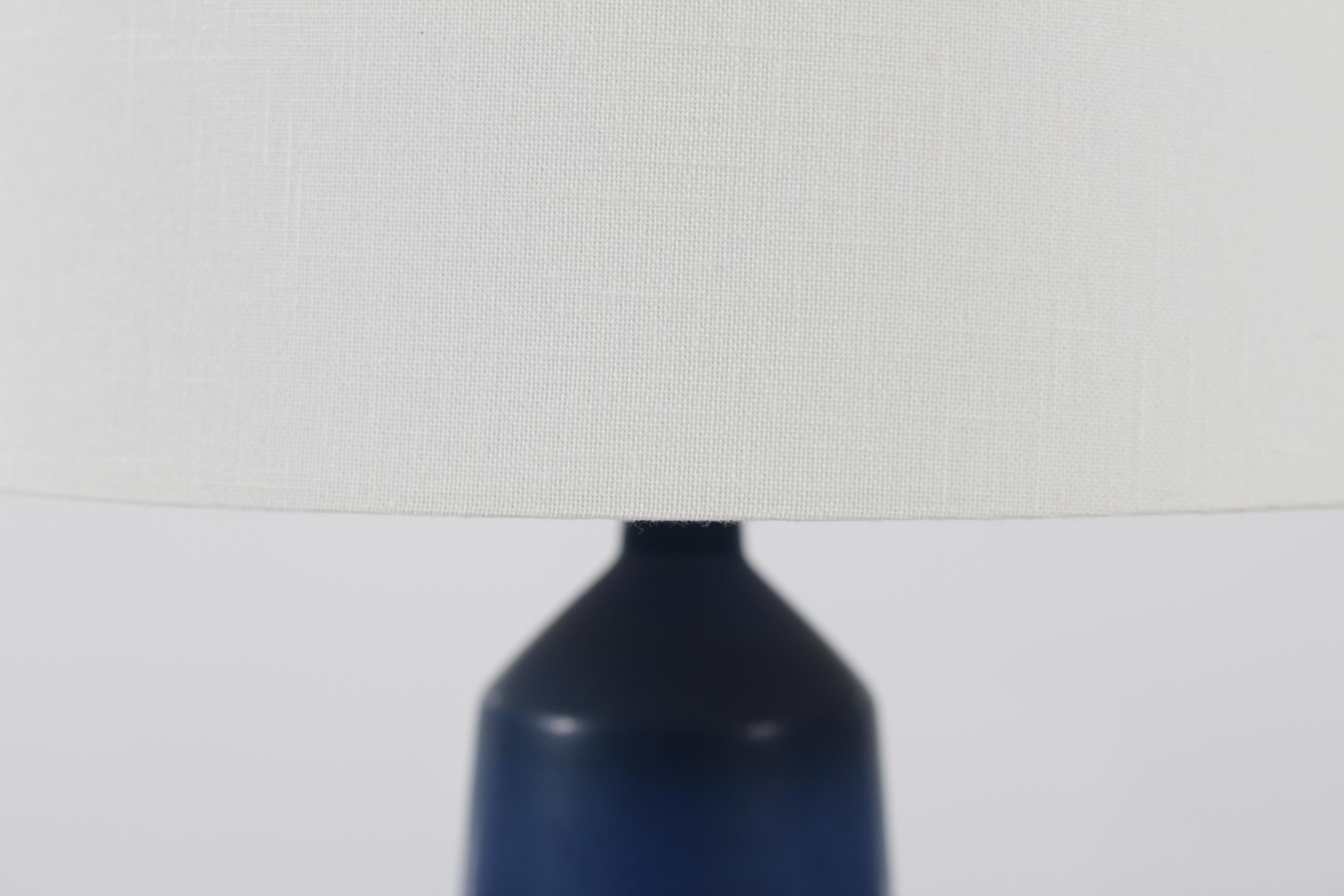 Tall slim Palshus table lamp with dark blue haresfur glaze designed by Per Linnemann-Schmidt.
A remarkable piece of Danish ceramic design.

Marked: Palshus + PLS for Per Linnemann-Schmidt + Denmark + DL13

Included is a new lampshade designed and