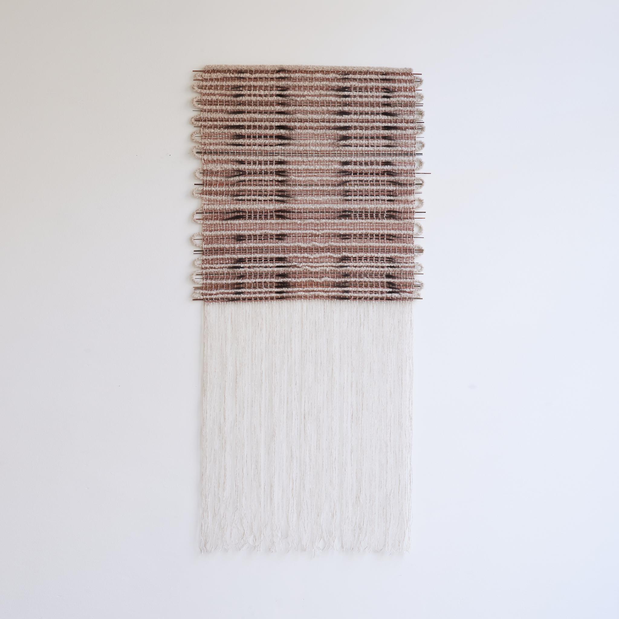 In Between #2 Wandskulptur von Delphine Cobbaert
Abmessungen: B 100 x H 207 cm
MATERIALIEN: Wolle, Leinen, Jute, bemaltes Holz, Rosshaar. 

Delphine Cobbaert ist eine belgische Textilkünstlerin, Designerin und Kunsthandwerkerin. Ihr künstlerischer