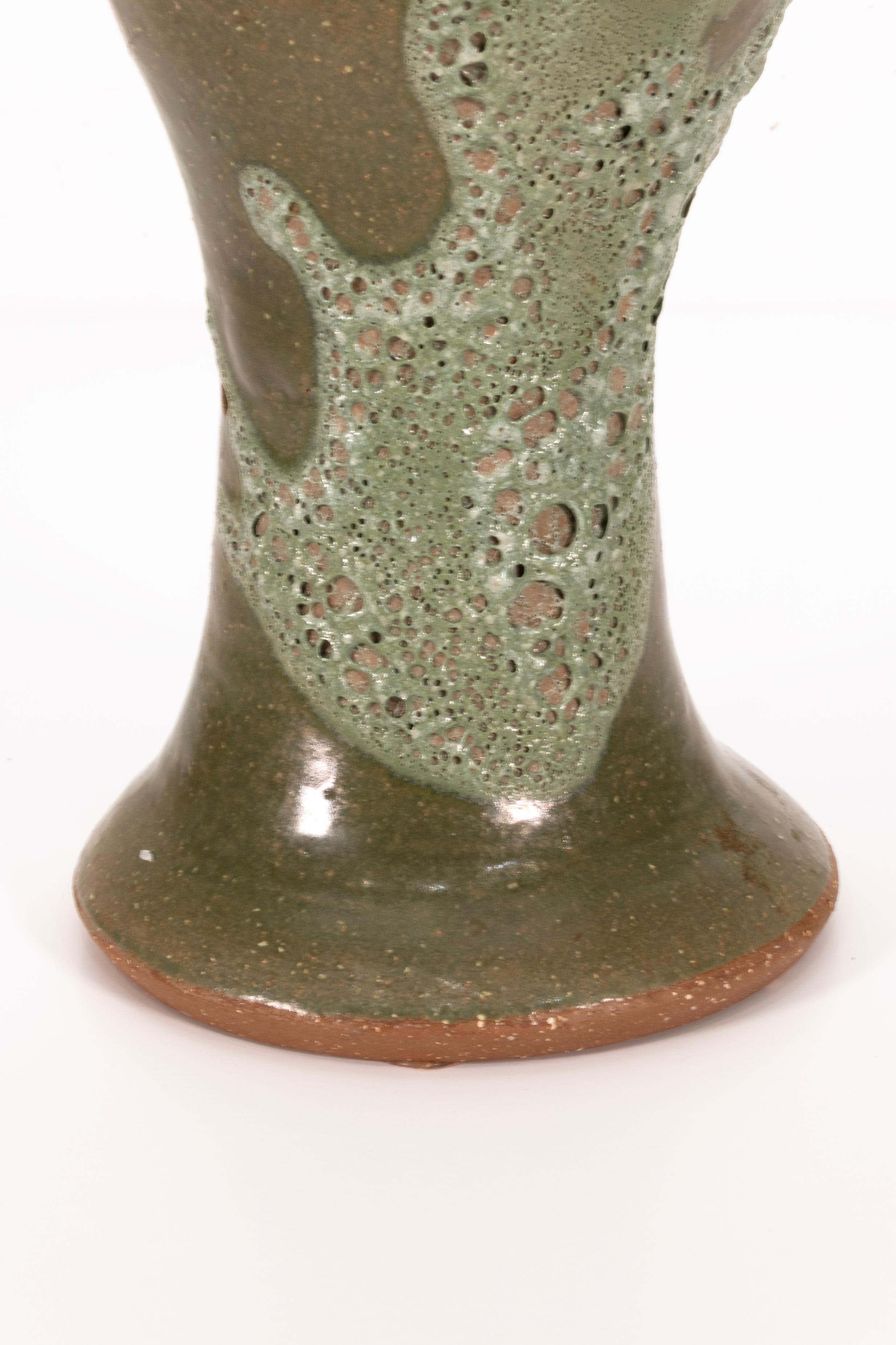 Signed Joanna Price Green Vase The overall shape of this vase, along with its intricate glaze details, enhances its natural, sculptural quality. Whether displayed alone or with plants, it adds an organic charm to any space, seamlessly blending art