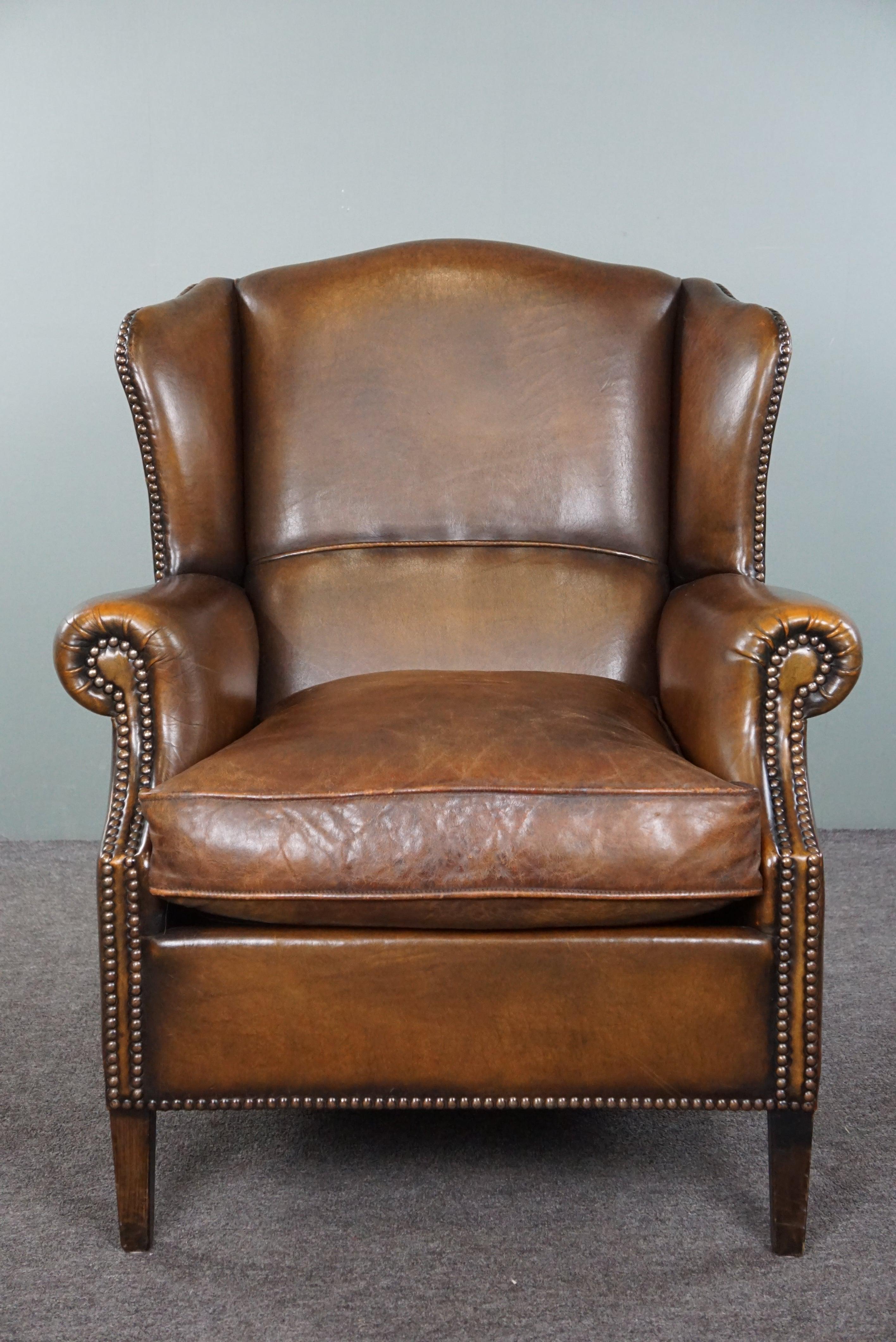 Offered is this beautiful wingback chair made of sheepskin, in good condition. A wingback chair in this gorgeous cognac color is something that many enthusiasts are passionate about. Of course, we understand why. These kinds of chairs are like true