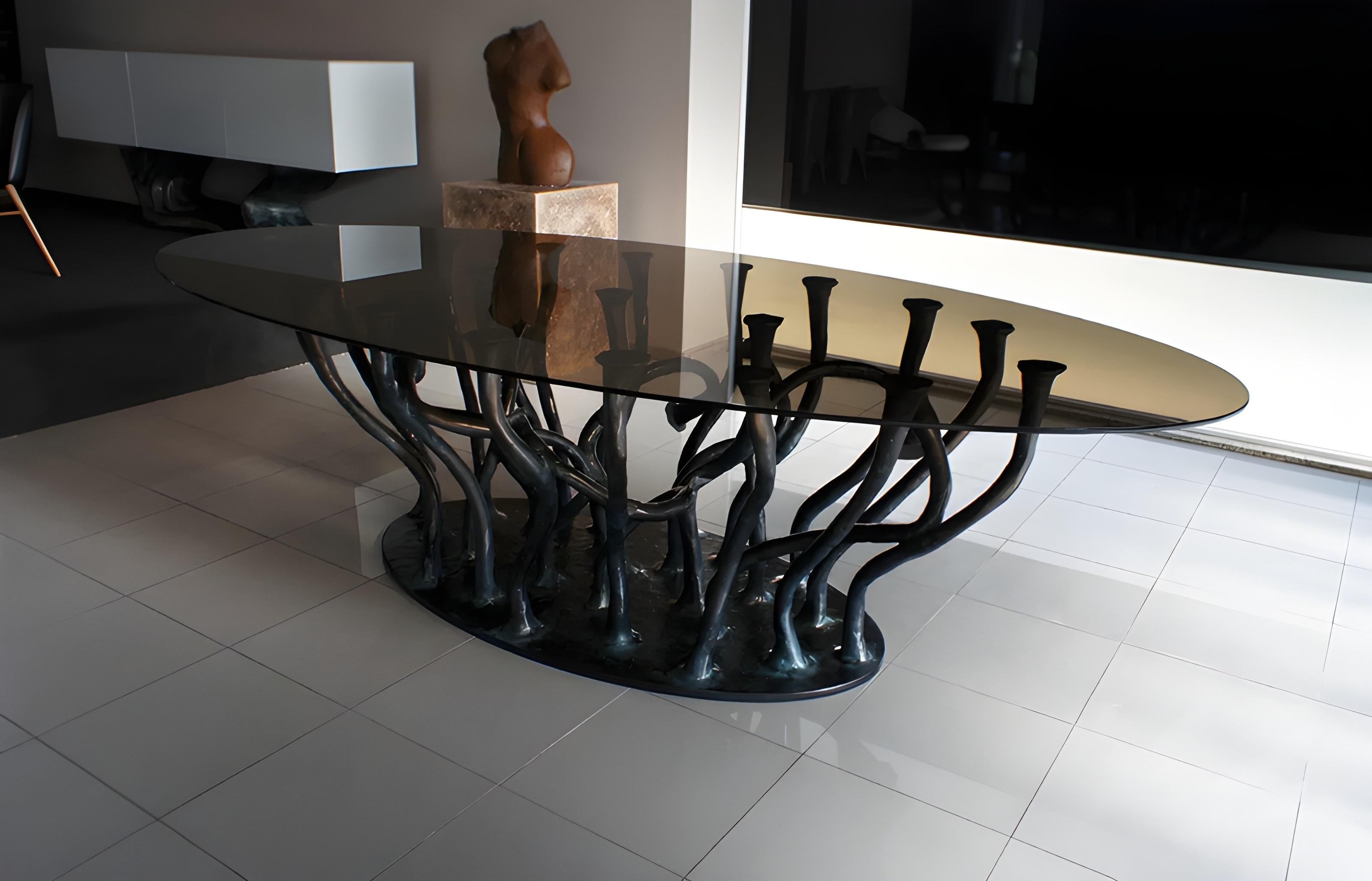 Le design s'inspire des branches d'arbres qui semblent émerger du sol. La structure organique des branches, qui sont lavées à la surface, porte une plaque de verre ovale fumé.
Des tailles personnalisées sont disponibles sur demande. 
Nous faisons de