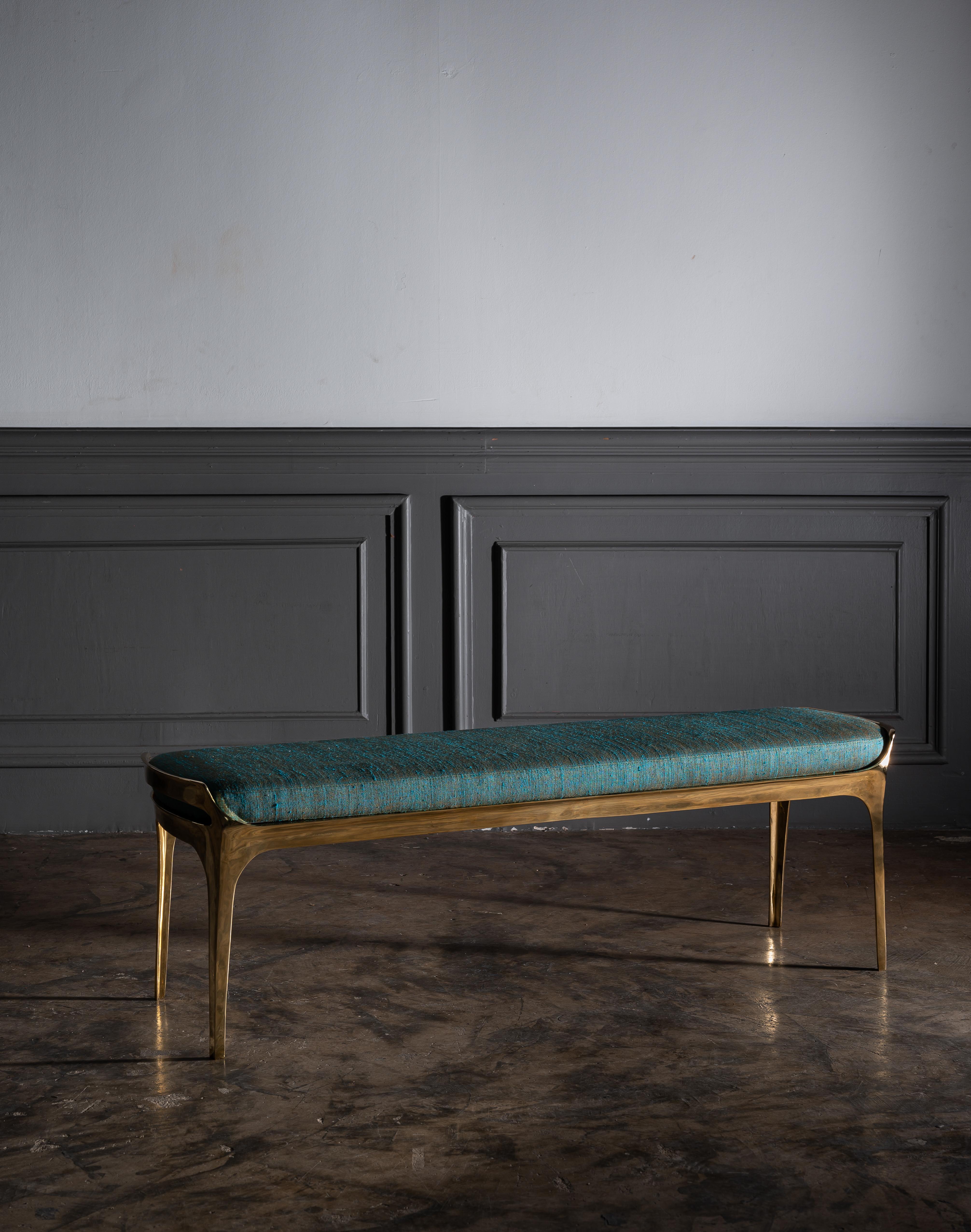 Available now and ready to ship! 

Sculptural cast bronze bruda bench in polished gold bronze by Elan Atelier.

Cast bronze Bruda bench in polished gold finish with marine blue green silk seat cushion. 

Dimensions/
W 50 x D 13.8 x Hh 16