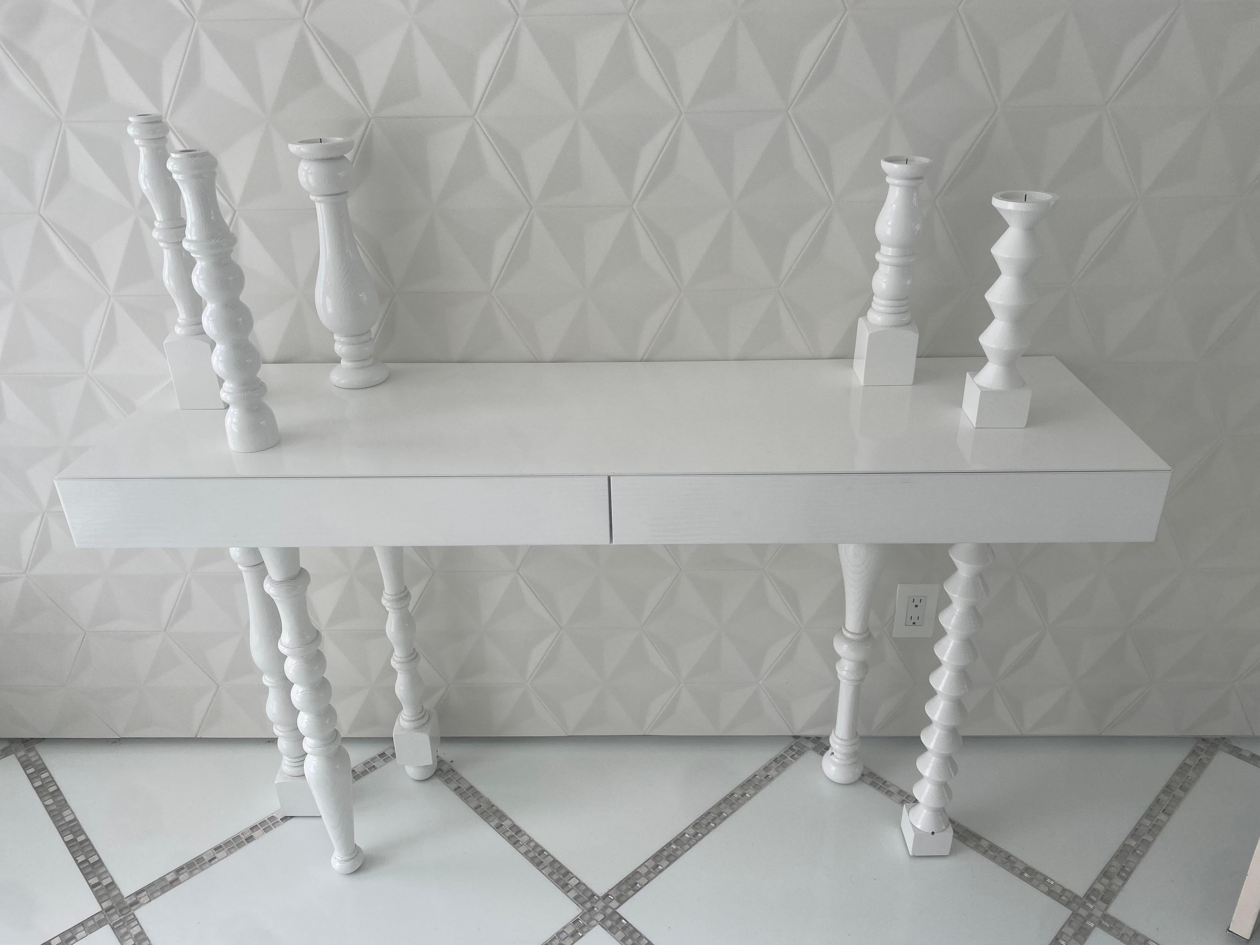 Lies The table was designed by Annabeth Philips designers for the brand Mogg. Ash wood table with legs and 7 candlesticks in turned solid. The white has now been discontinued. Very special design for this table, minimal and dynamic. The candlesticks