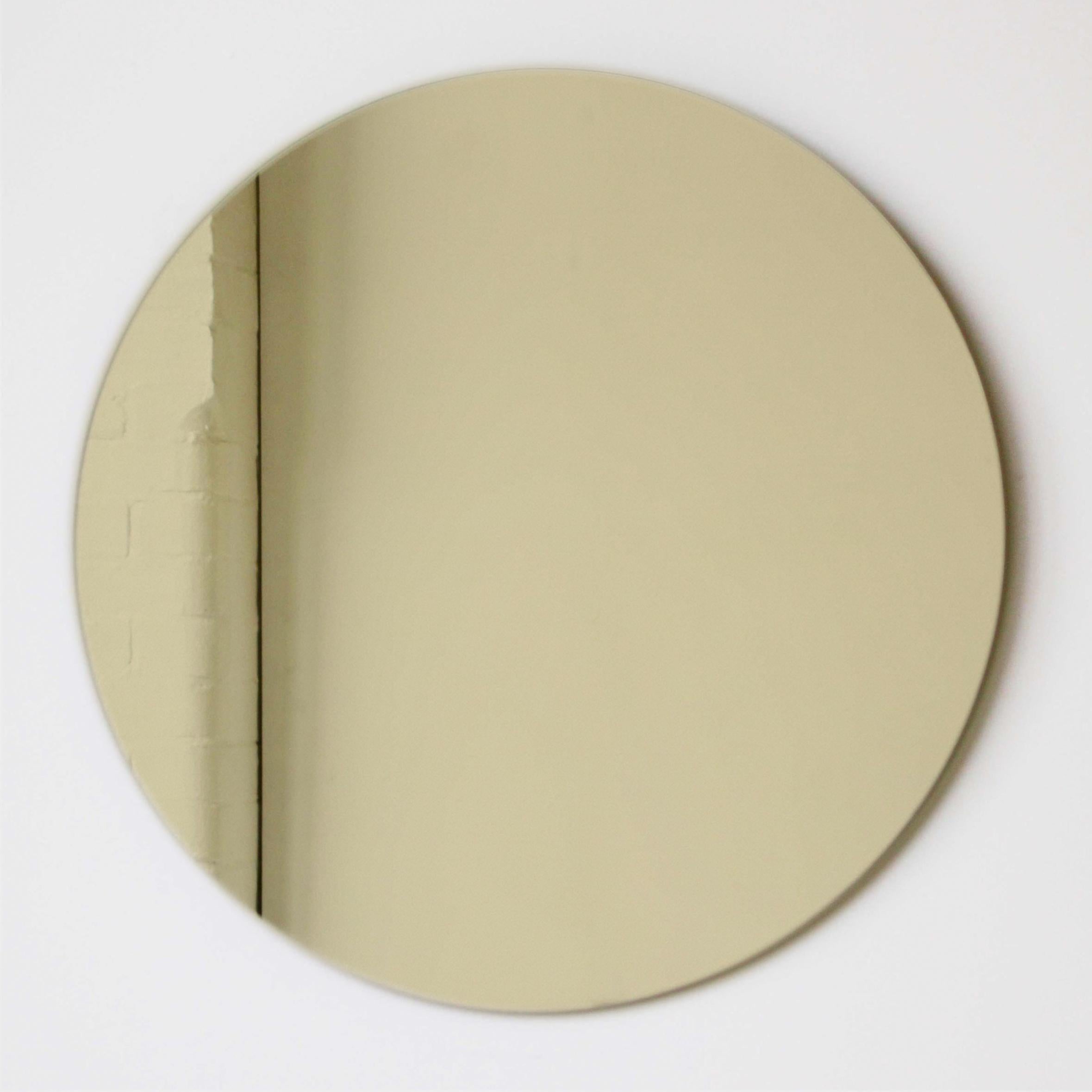 Cet article est disponible en stock et peut être emballé et expédié dans les 5 jours ouvrables suivant la confirmation de la commande.

Miroir rond Orbis™ minimaliste sans cadre, teinté d'or, avec un effet flottant. Conçu et fabriqué à la main à