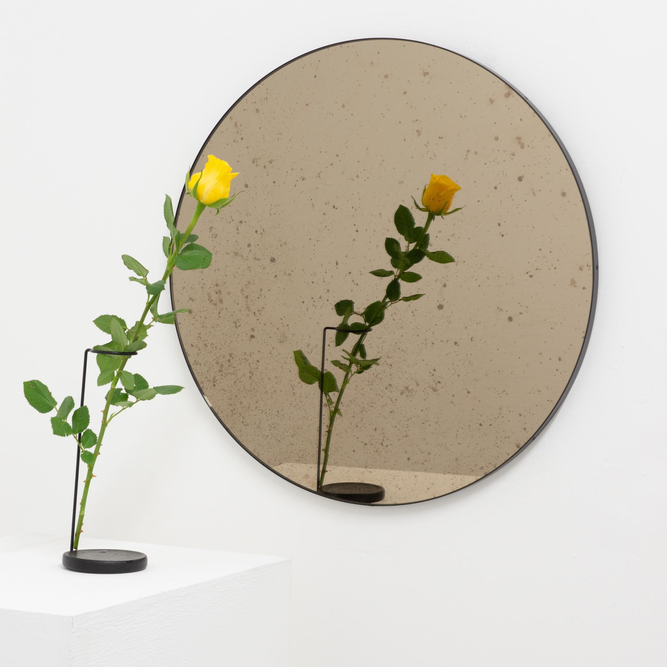 En stock, prêt à être expédié.

Ravissant miroir rond antiquaire teinté de bronze avec un élégant cadre noir. Conçu et fabriqué à la main à Londres, au Royaume-Uni.

Equipés d'un ingénieux système de tasseaux français (lattes fendues), ils peuvent