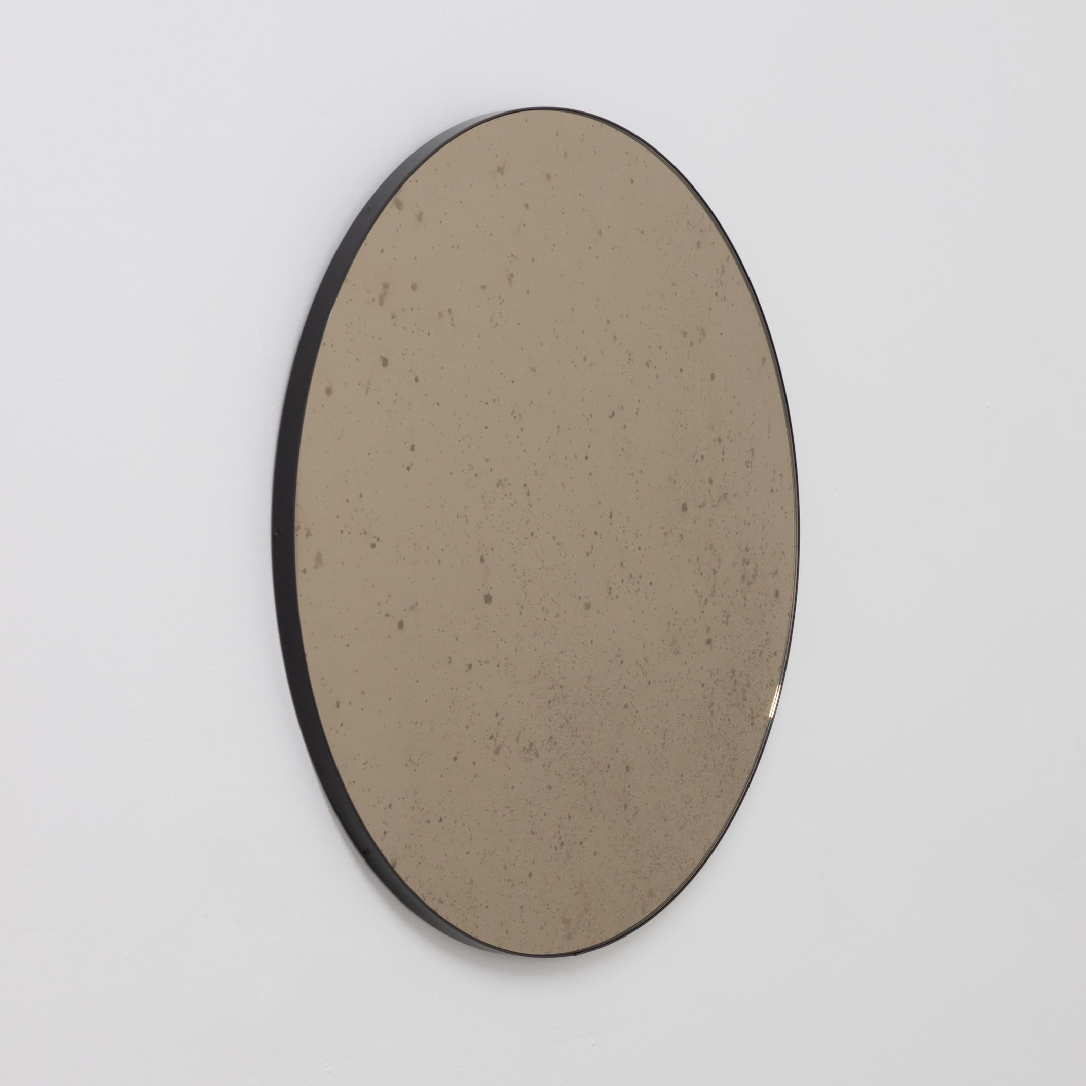 In Stock, Orbis Round Bronze Antiqued Modernist Mirror with Black Frame, Medium In New Condition For Sale In London, GB