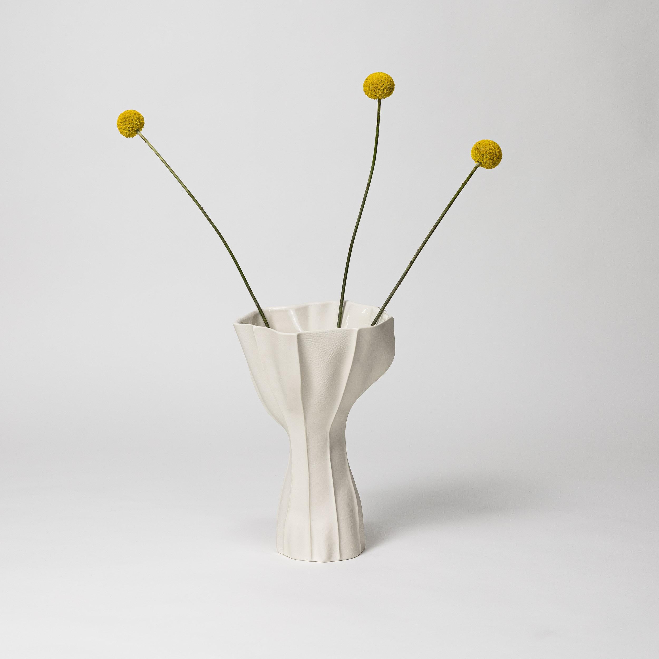 Un vase sculptural et organique en porcelaine avec une surface extérieure texturée en cuir et un intérieur glacé brillant. En raison du processus de production, chaque article est unique. 

Une multitude de panneaux de cuir sont cousus ensemble pour