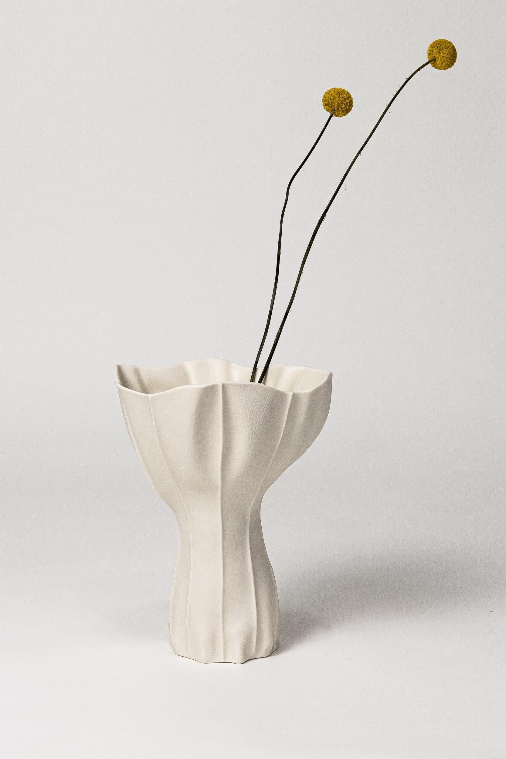 An sculptural and organic porcelain vase with leather textured exterior surface and satin glazed interior. As a result of the production process each item is one-of-a-kind. 

A multitude of leather panels are sewn together to create the leather mold