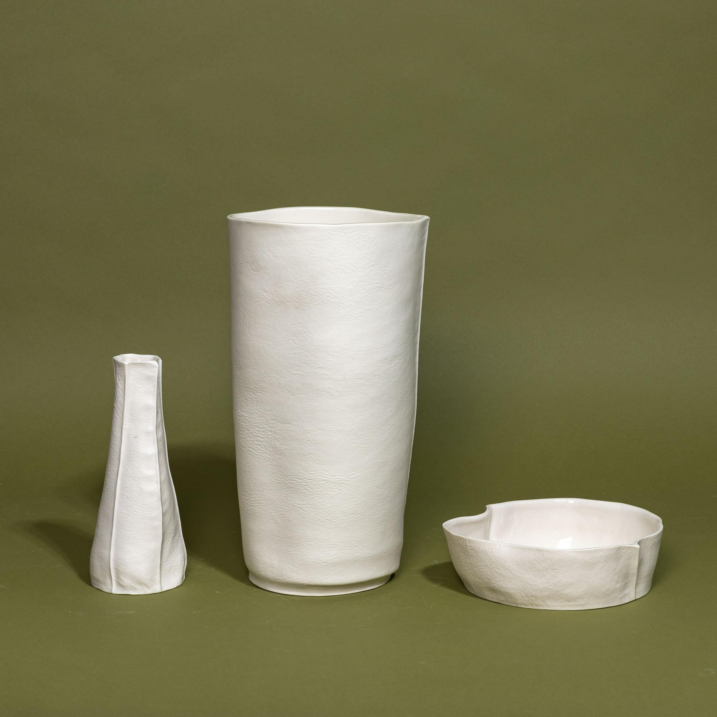 A grouping of one-of-a-kind Kawa Series items that are handcrafted by Luft Tanaka Studio by casting porcelain into sewn leather molds. 

Sold as a set of 3 items: 2 vases and a catchall dish. 

As a result of the production process, each item is