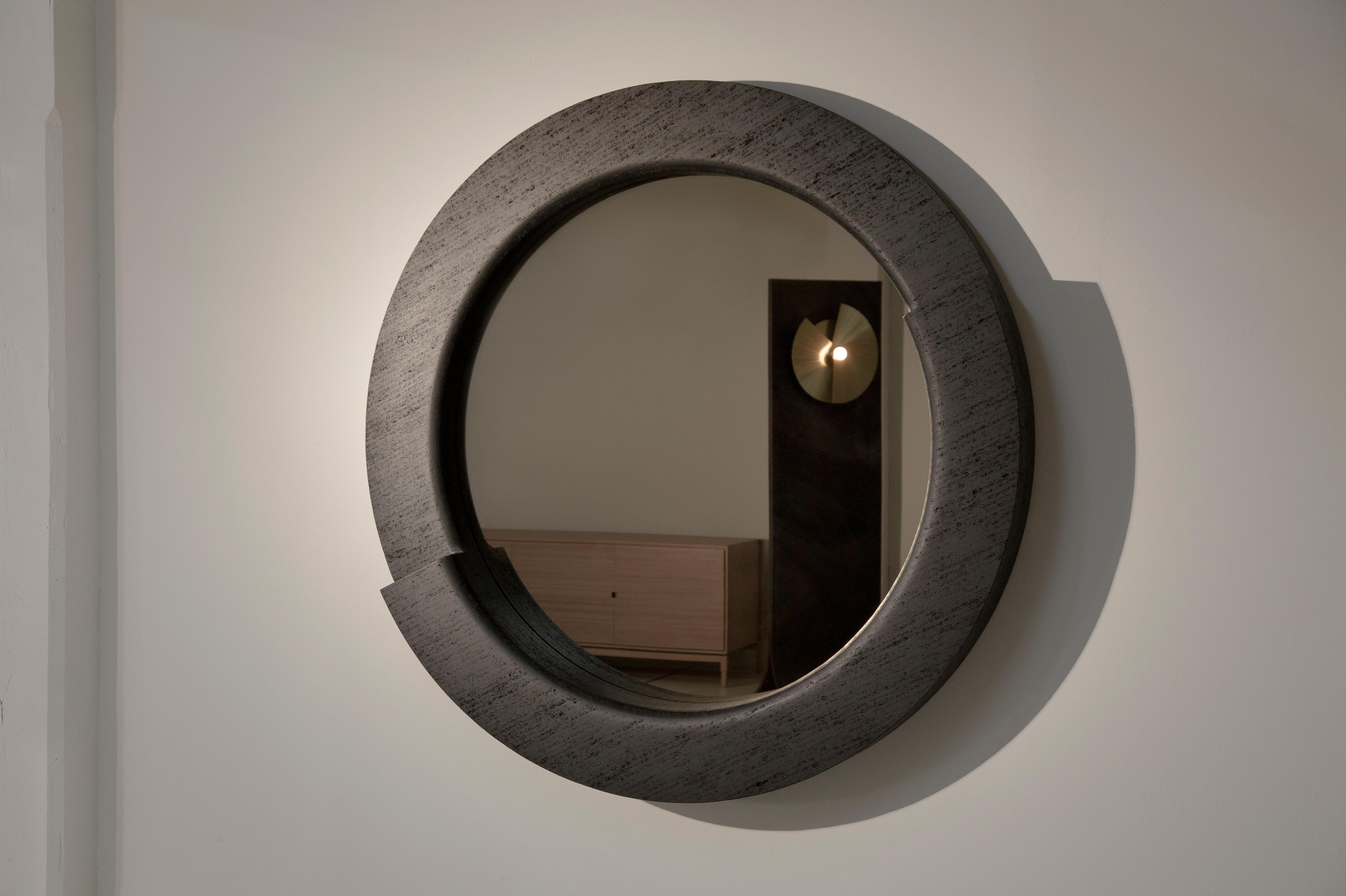 Brutalist architecturally inspired Tomba Mirror draws inspiration from Carlo Scarpa's Brion Tomb and its famous intersecting round windows. 
Layers of our proprietary Maykume (wood that resembles stone) are sculpted and carved to create bold curves