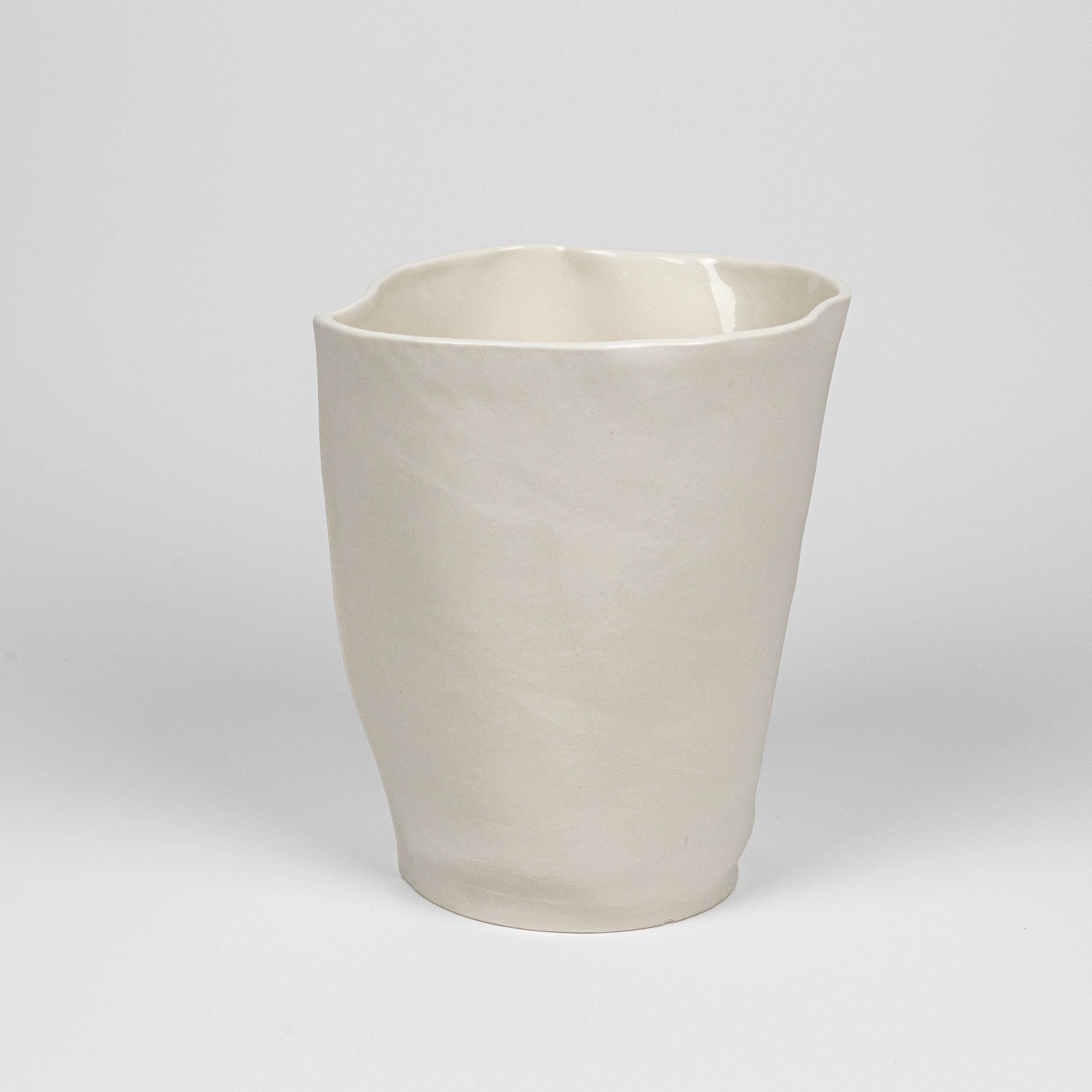 A porcelain vessel with an fabric-like form and leather texture, made by casting liquid porcelain in sewn leather molds. Clear glaze applied on interior surface. As a result of the production process each vase is one-of-a-kind. 

Dimensions
7
