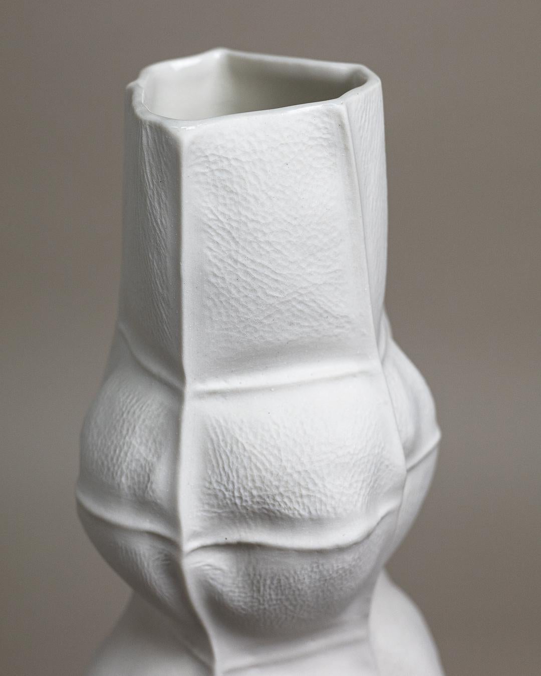 Un grand vase à fleurs en porcelaine avec une surface organique et semblable à du tissu. Un vernis transparent est appliqué sur la surface intérieure. En raison du processus de production, chaque vase est unique. 

La pièce est étanche et retient