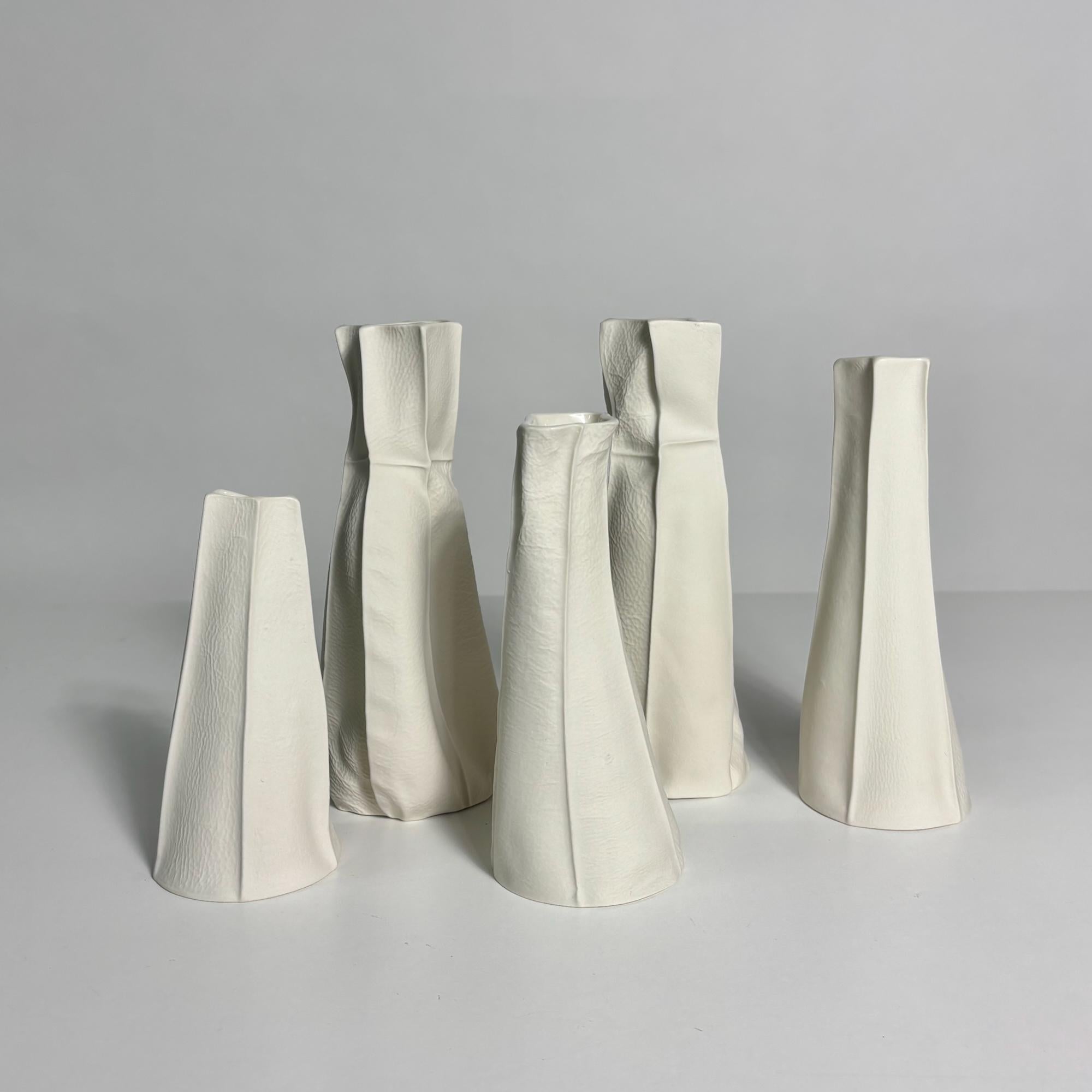 En stock. Expédition en 1-3 jours. 

Vases organiques en céramique blanche avec surface extérieure texturée en porcelaine brute et intérieur émaillé transparent. En raison du processus de production, chaque article est unique.

Ensemble de 5