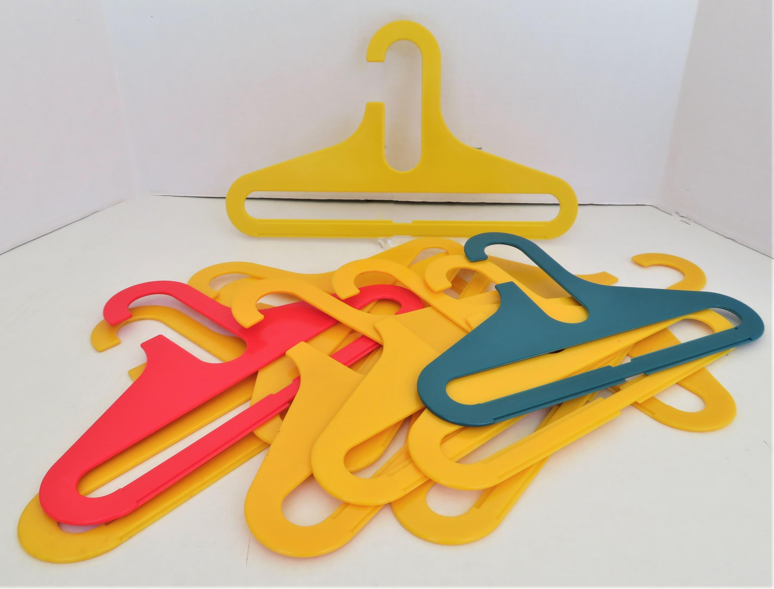 From the 1970s in the style of Ingo Maurer’s Op Pop FLAIR colorful heavy plastic clothes hangers. A set of 11 colorful plastic hangers for children clothing, 10 of the same size, 12 1/2 inches wide, and one a bit wider in yellow, 14 1/2 inches wide.
