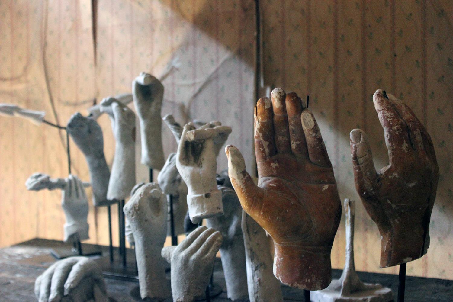 The large group of twenty three plaster moulded maquettes mainly being human hands, digits and legs, some holding flowers, and two being free standing to include an ostrich foot, the others each mounted on five painted steel rod bases and surviving