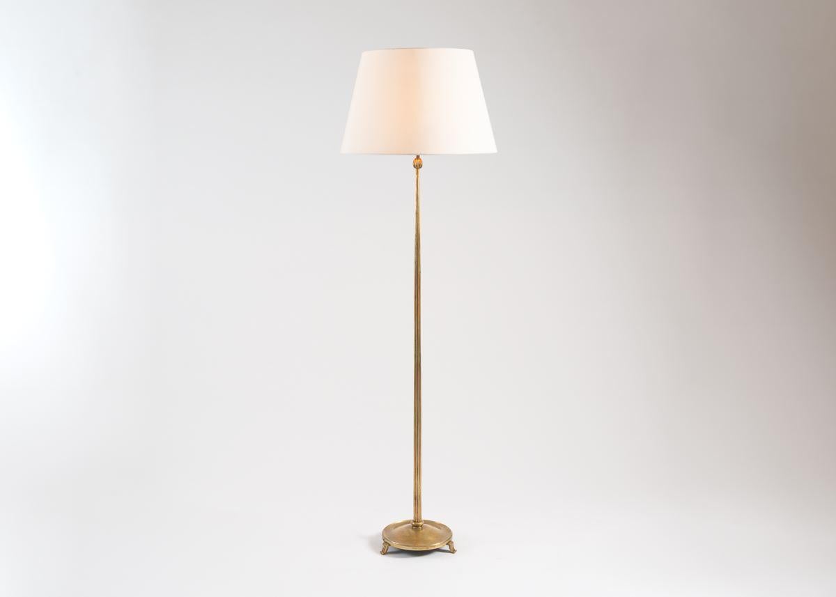 Posées sur trois petits pieds, les bases circulaires de cette paire de lampadaires semblent flotter juste au-dessus du sol, leurs montants étant minces et cannelés.