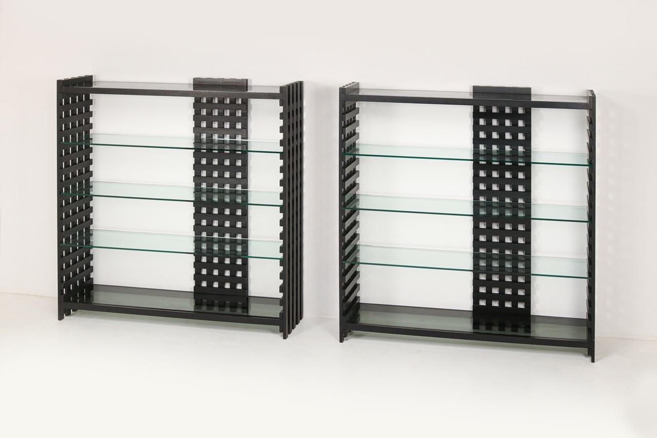 Immerse your space in the timeless allure of 1970s Italian design with our dual grand bookshelves. Its fine materials, lacquered wood and crystal shelves, exudes timeless sophistication, splendidly harmonizing form and function. Its geometric