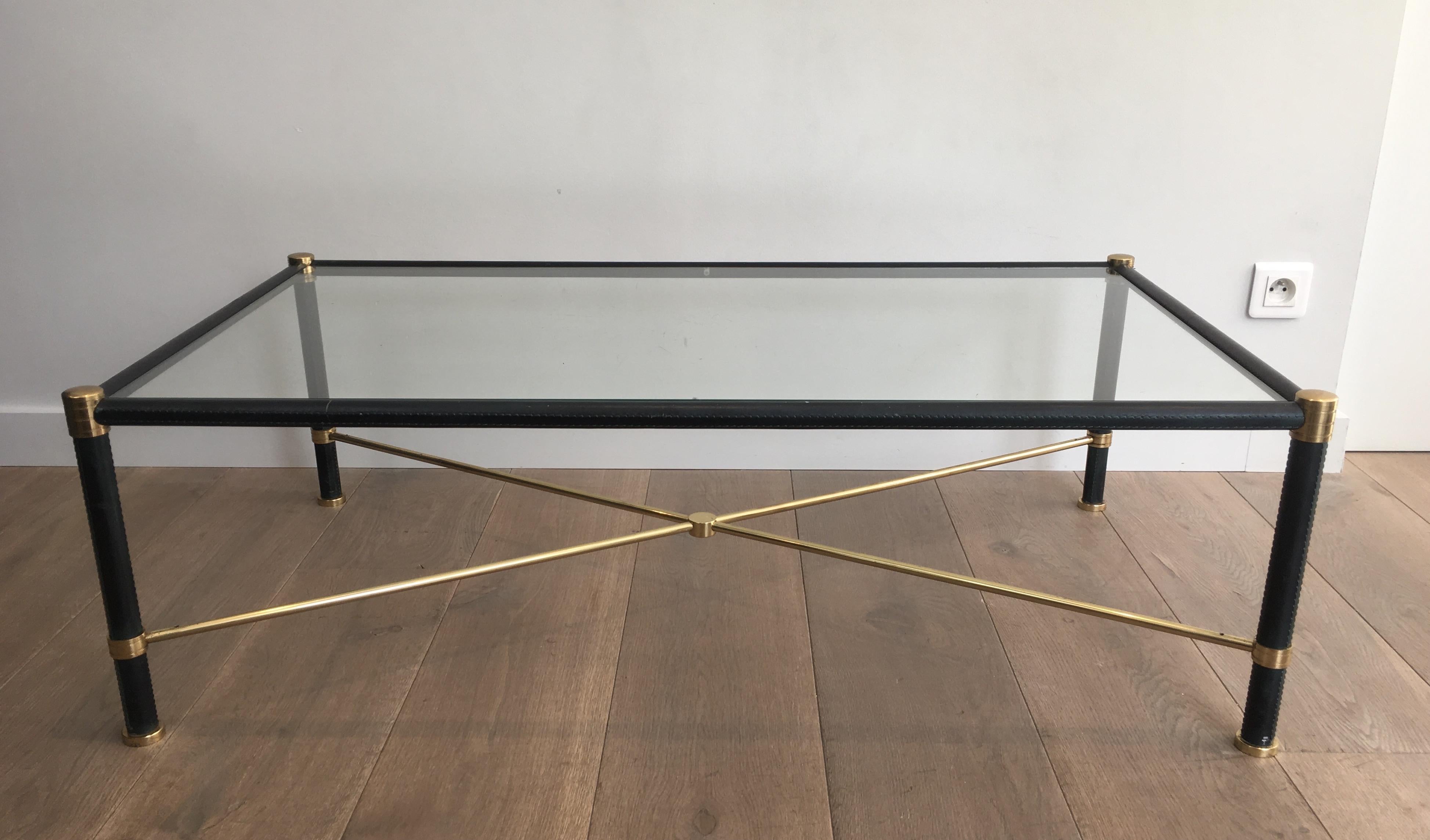 This beautiful coffee table is made of brass and black leather. This is a very nice work in the style of In the Style of Jacques Adnet. Rectangular brass and black lacquered coffee table, French, circa 1970.
 