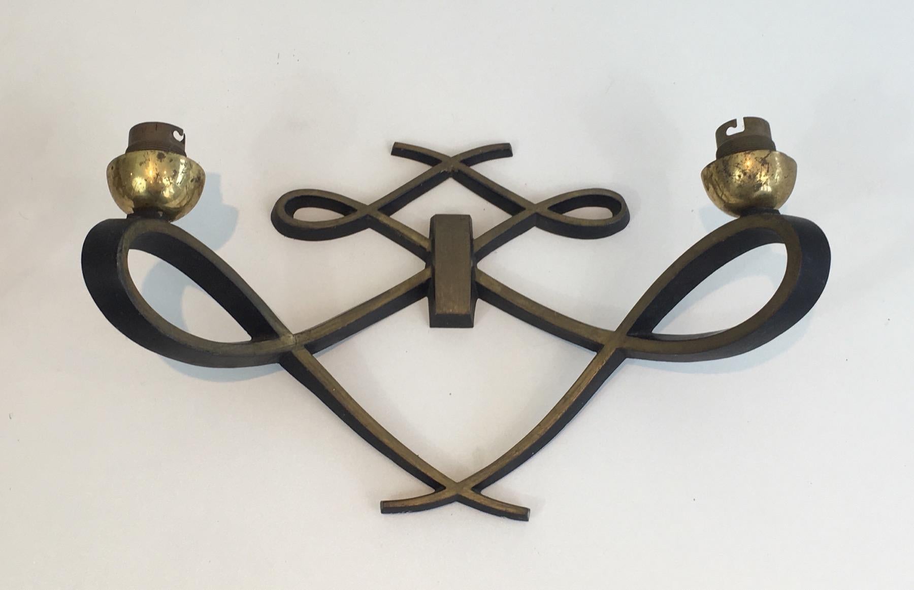This very nice pair of wall sconces is made of black lacquered metal and brass.
This is a very interesting work in the style of famous French designer Jules Leleu, circa 1950.