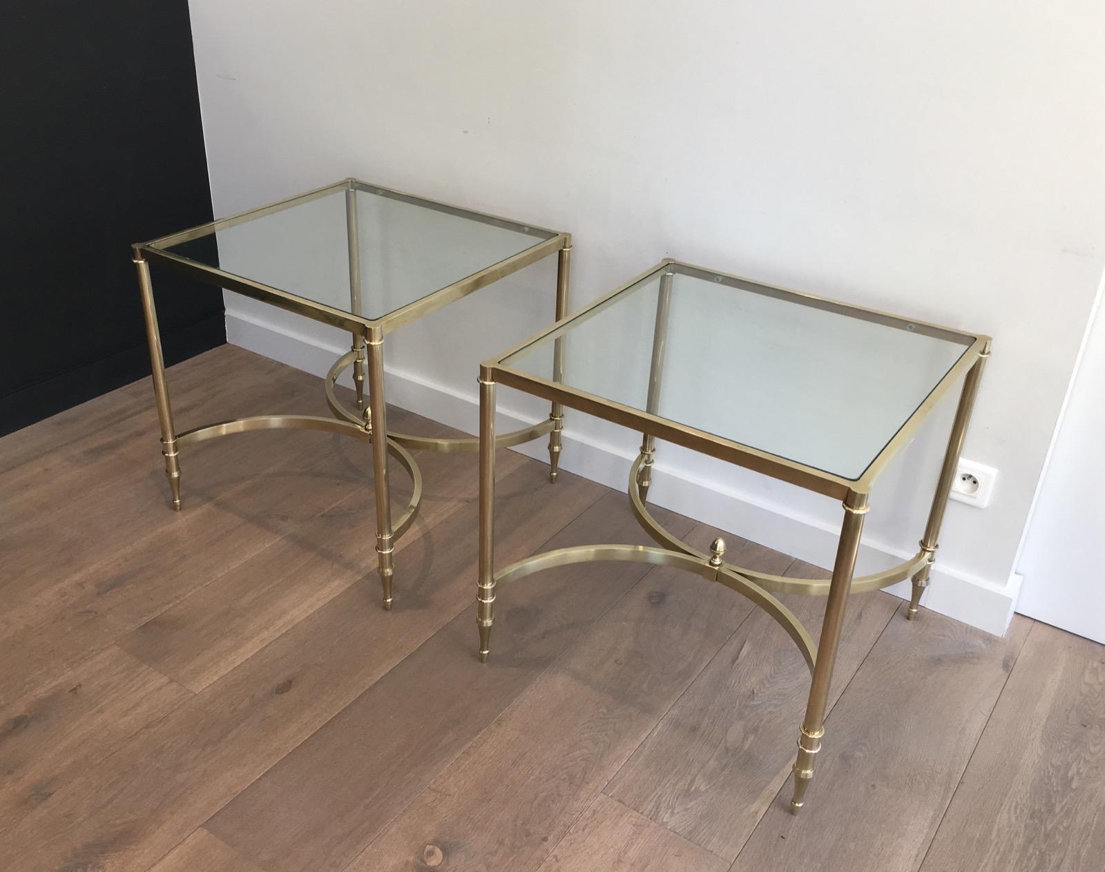 This rare pair of neoclassical side tables is made of brass with clear glass shelves. This is a large model. These side tables are a French work, in the style of famous Maison Jansen, circa 1960.
